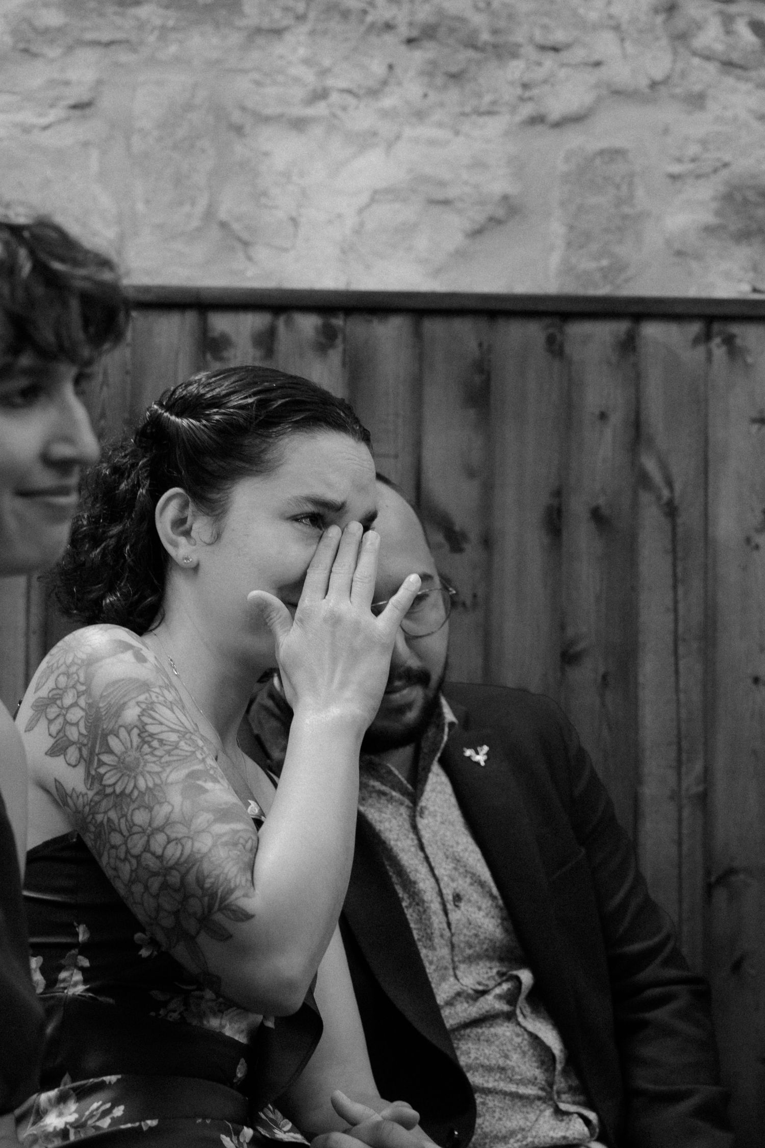 Black and white photo of emotional wedding moment with guests sharing laughter.