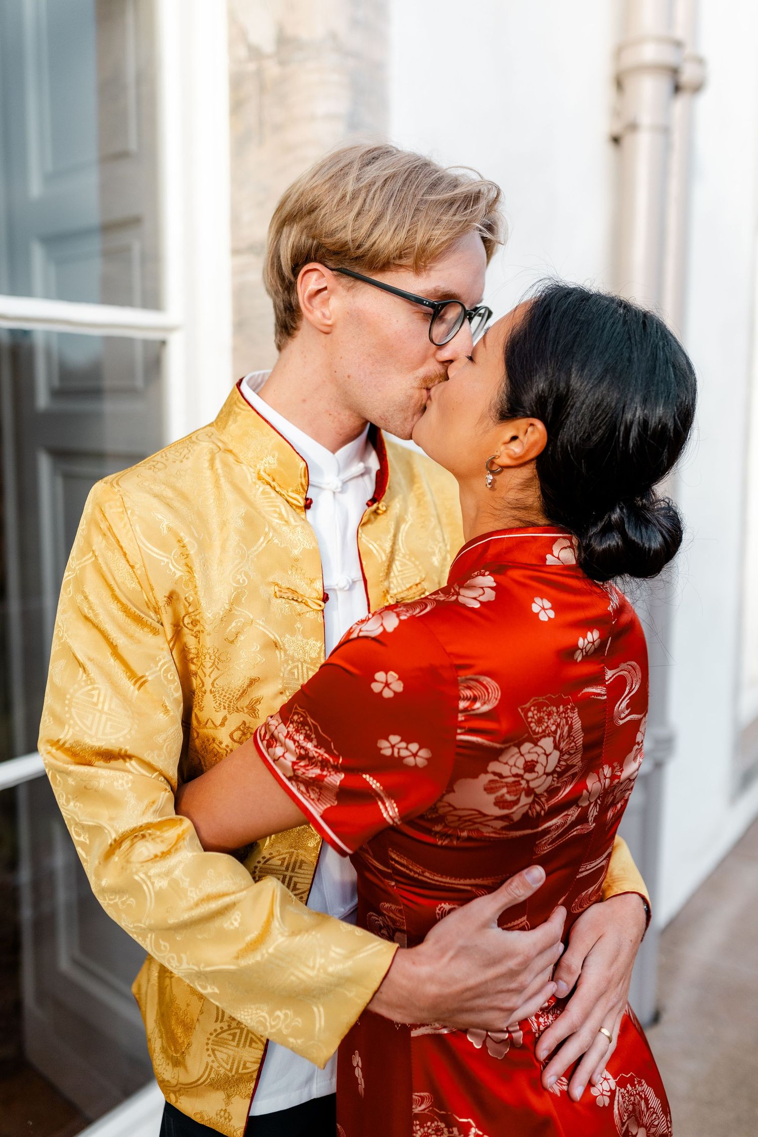 Romantic moment between couple in traditional Chinese and Western fusion wedding attire.