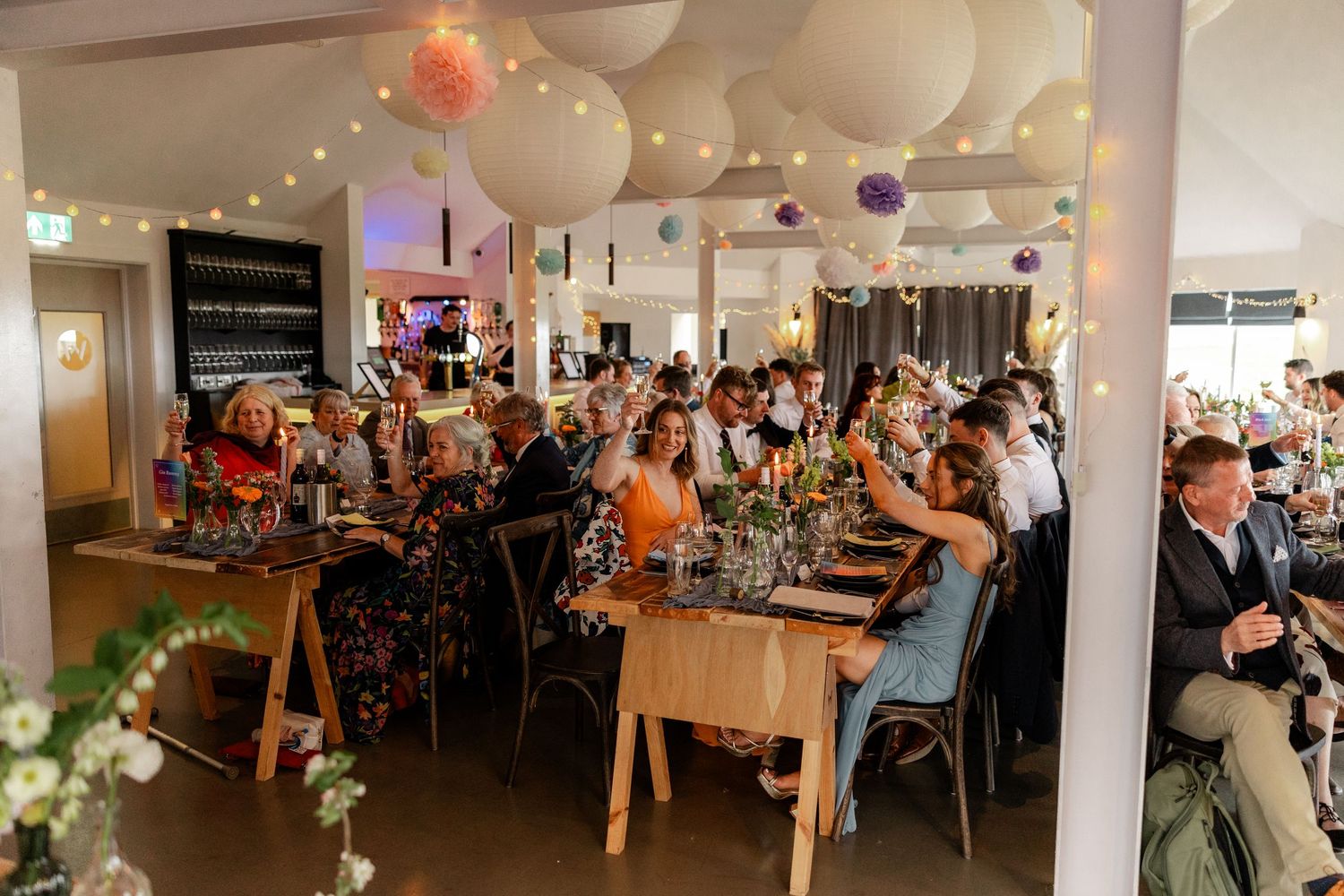 Wedding reception venue decorated with white balloons and string lights creating a festive atmosphere.