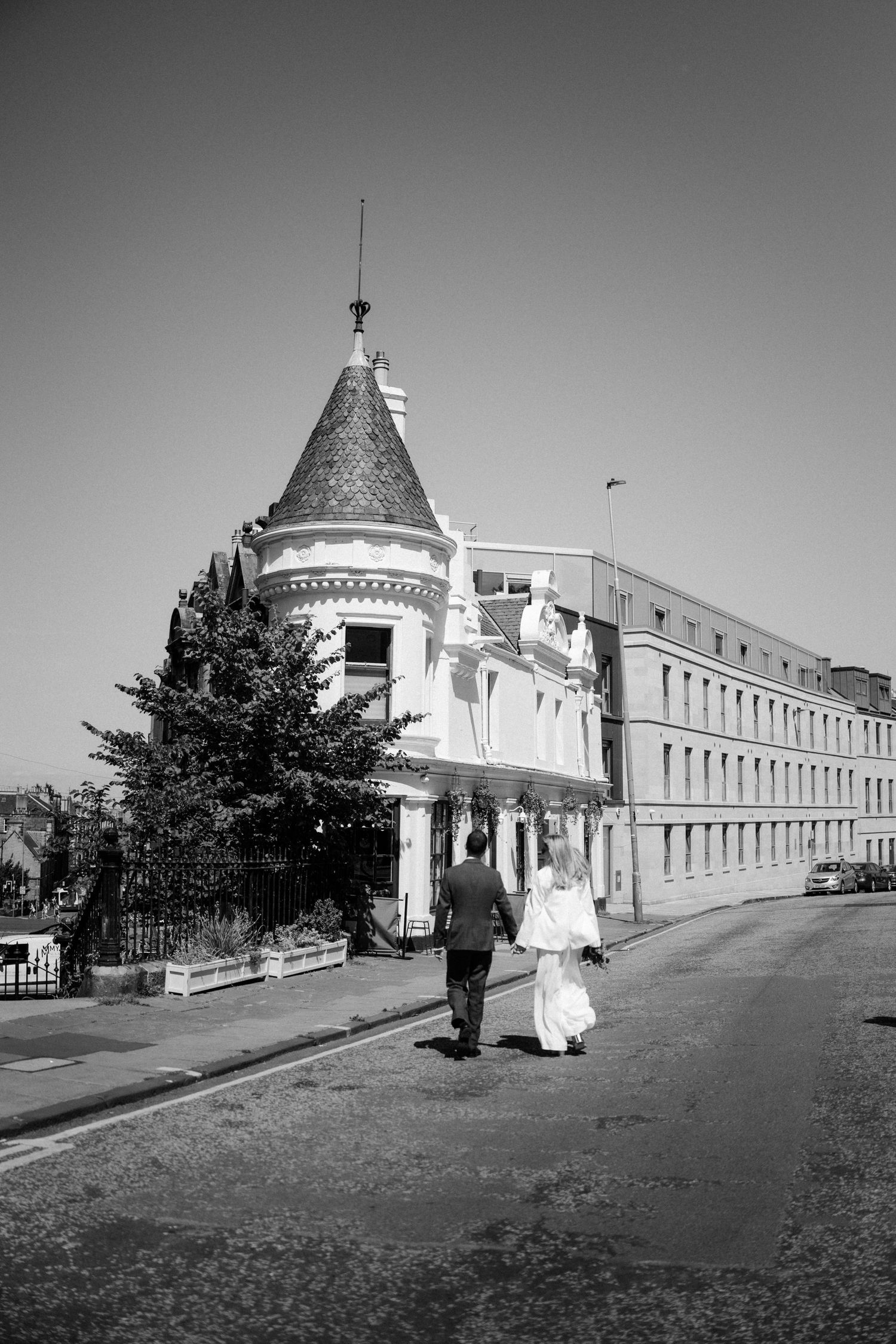 Black and white wedding photos at historic building with architectural details.