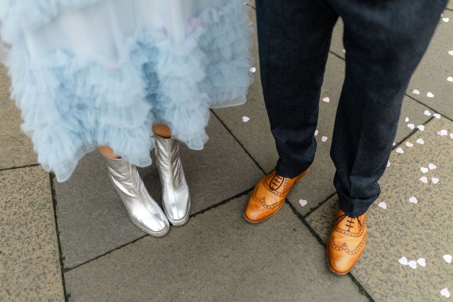 Wedding shoes and dress details showing white gown hem and brown leather footwear.