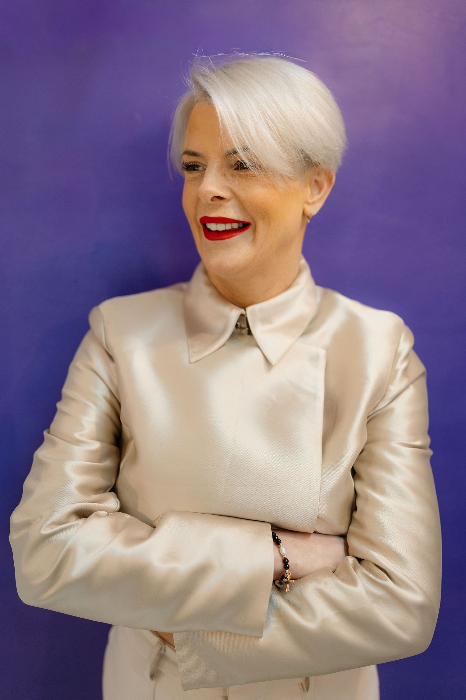 A series of five fashion portraits showing a model in a white satin blazer against a purple background.