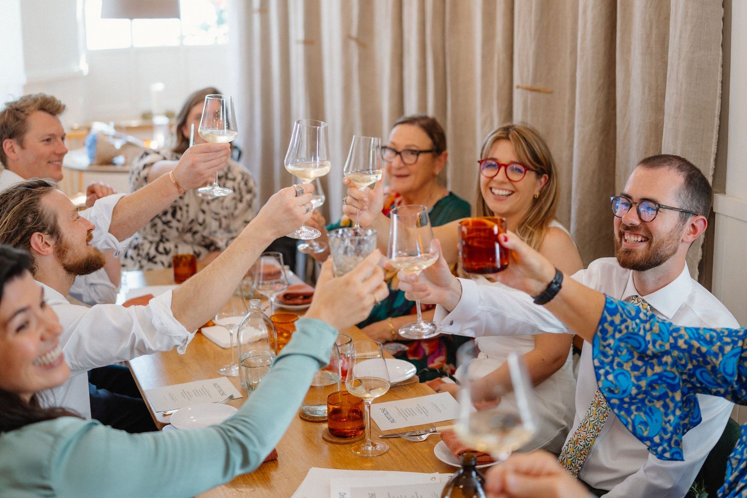 A group of people enjoying drinks and conversation at a social gathering in an indoor setting.