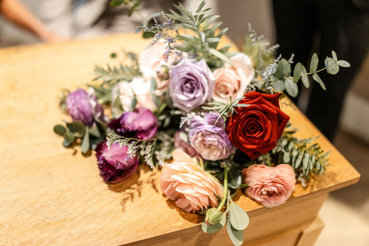 Beautiful wedding floral arrangements with roses and eucalyptus on a wooden surface.