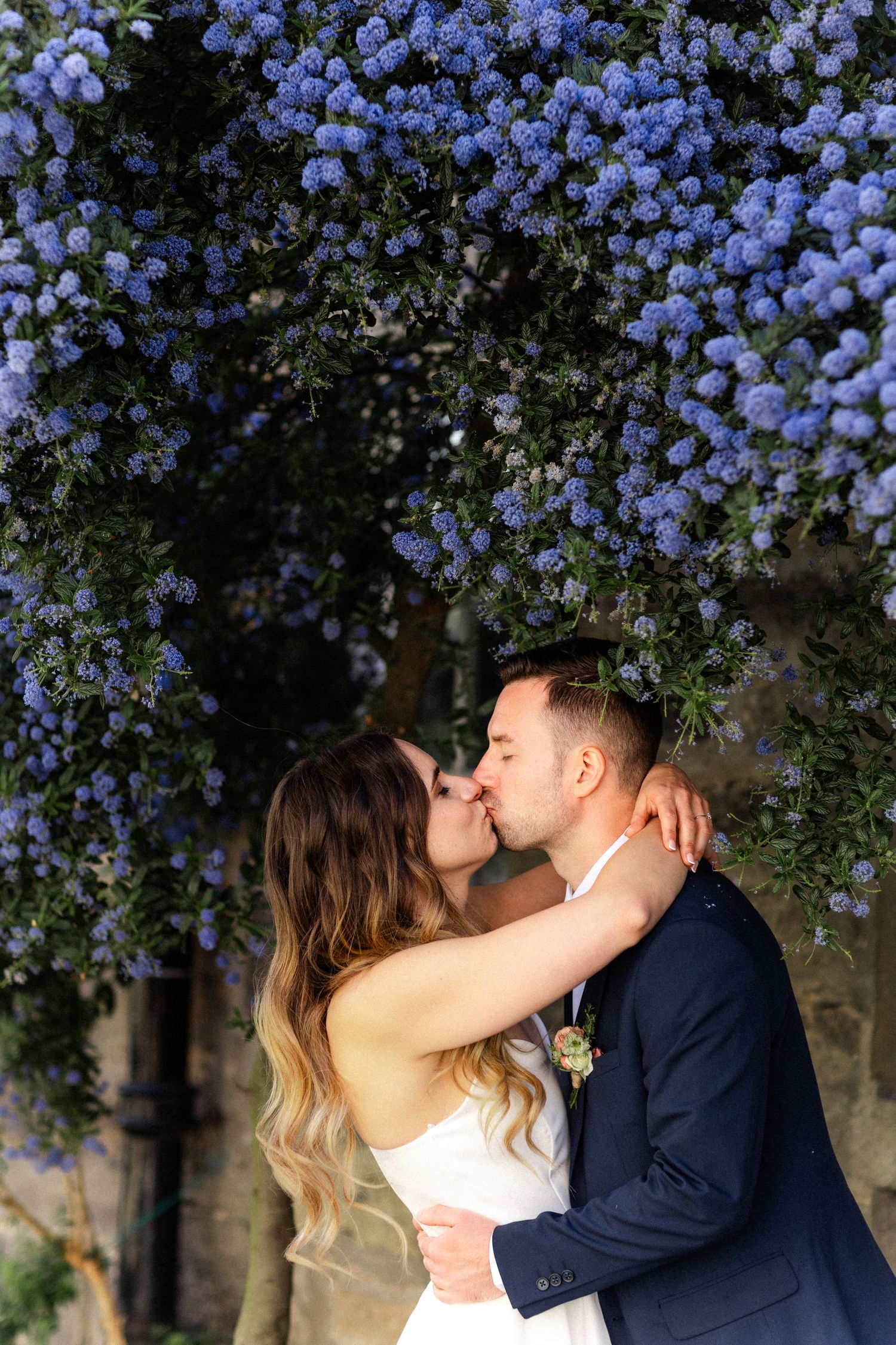 A romantic moment under blooming purple wisteria flowers.