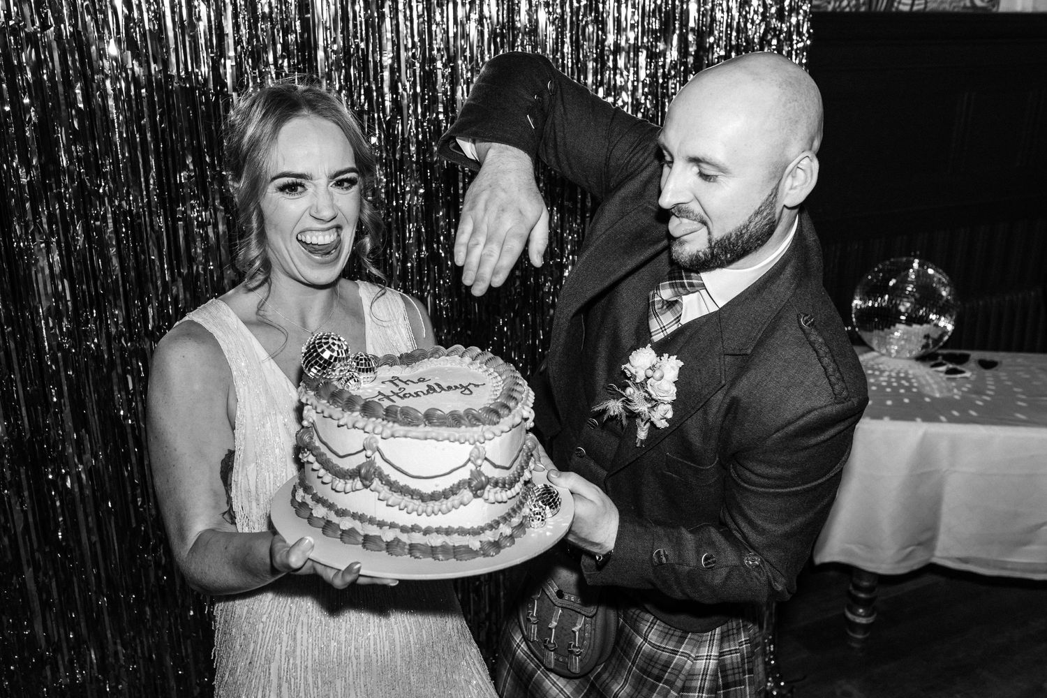 Wedding couple shares playful moments with cake at their reception celebration.
