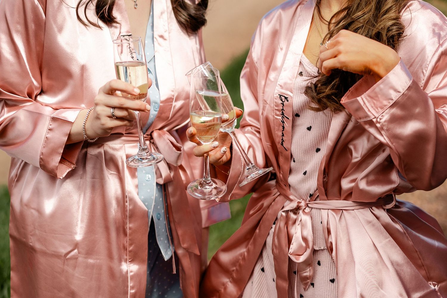 Close-up details of pink satin robes with delicate embroidery.