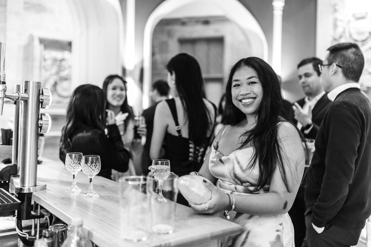 Black and white photo of guests mingling at a celebration reception.