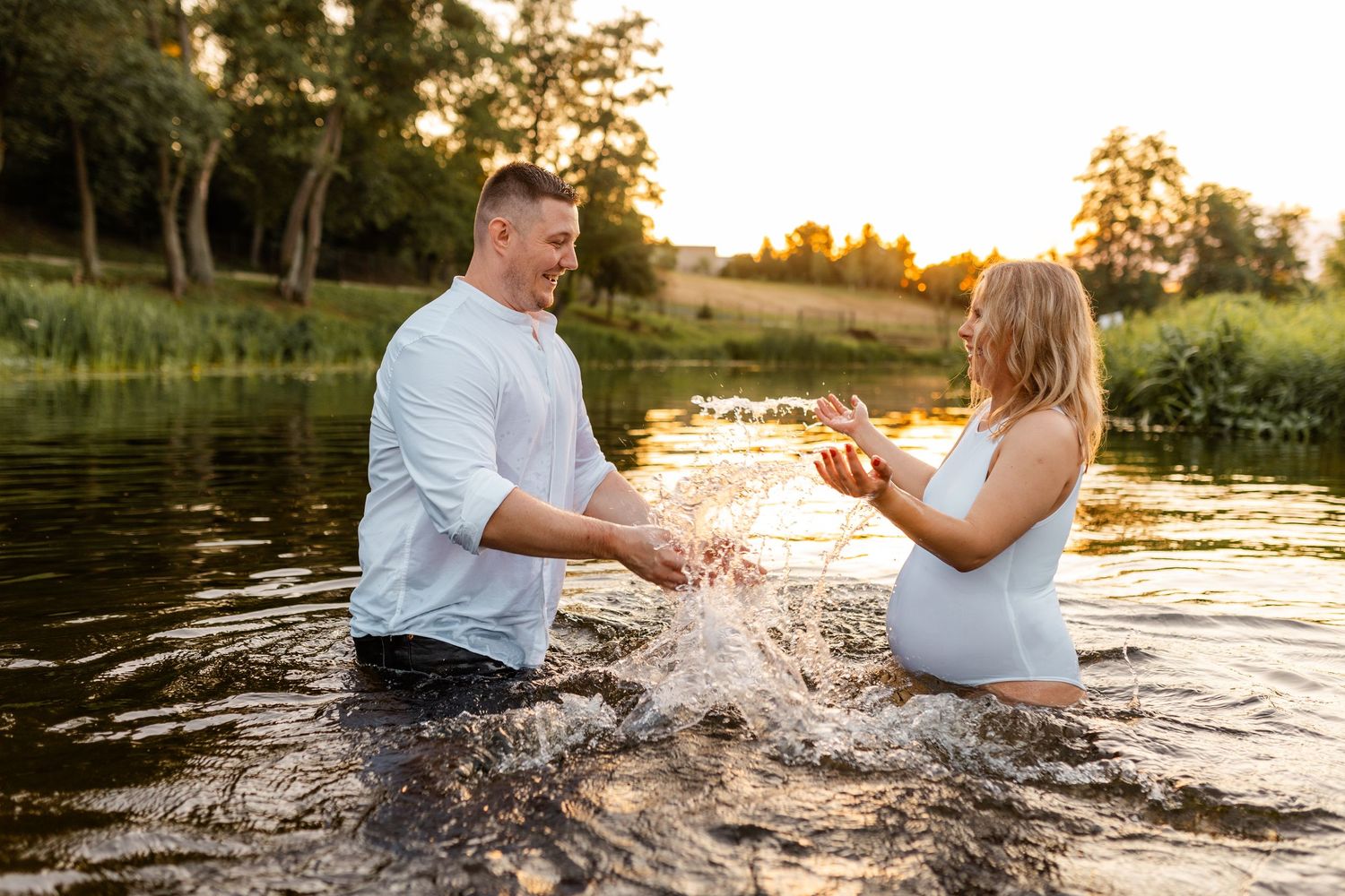 Playful water splashing moments captured during a sunset lake photoshoot.