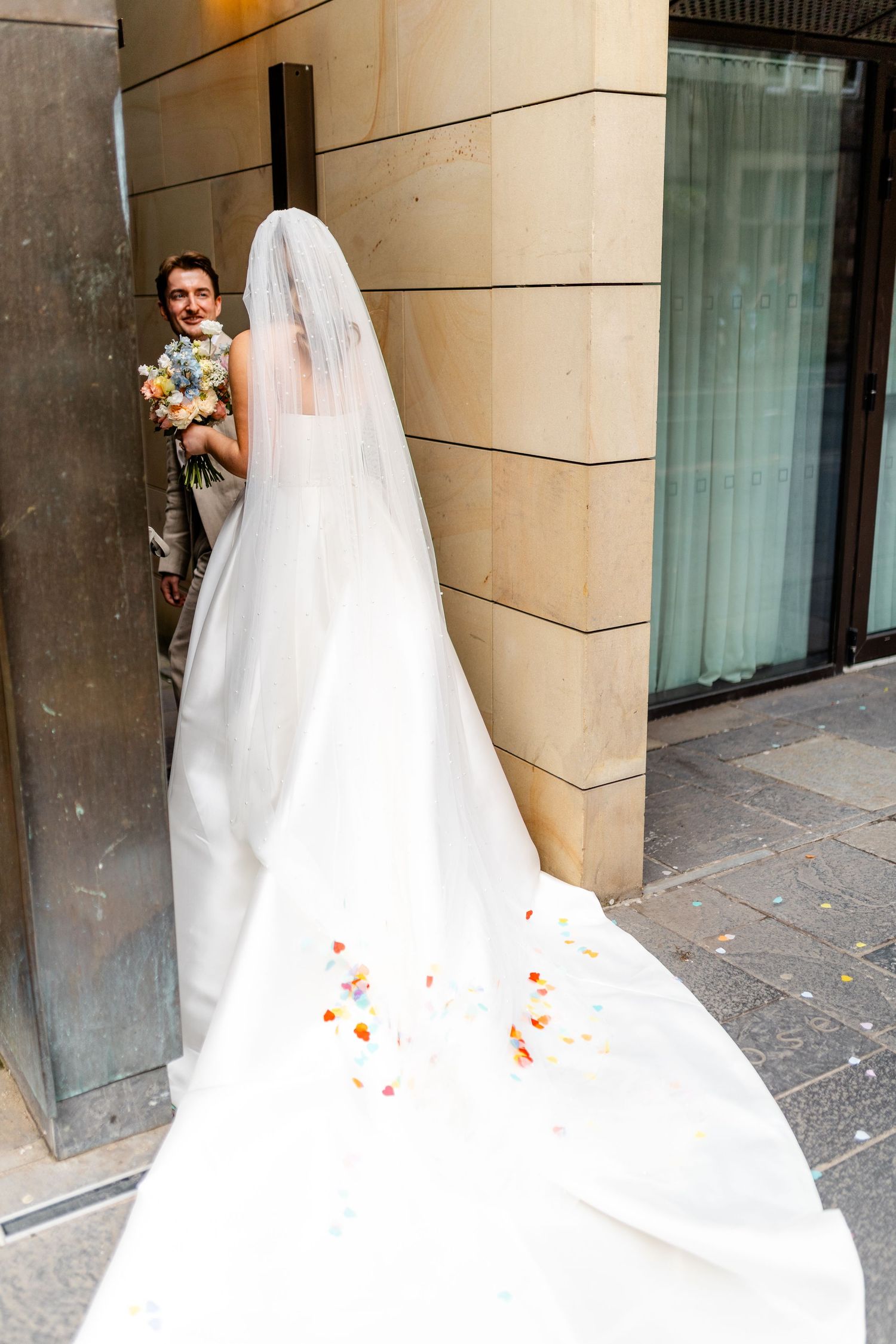 Sequence of a bride in flowing white dress walking through stone archways.