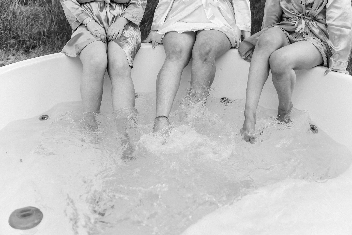 Group of friends lounging in a hot tub enjoying drinks and conversation.