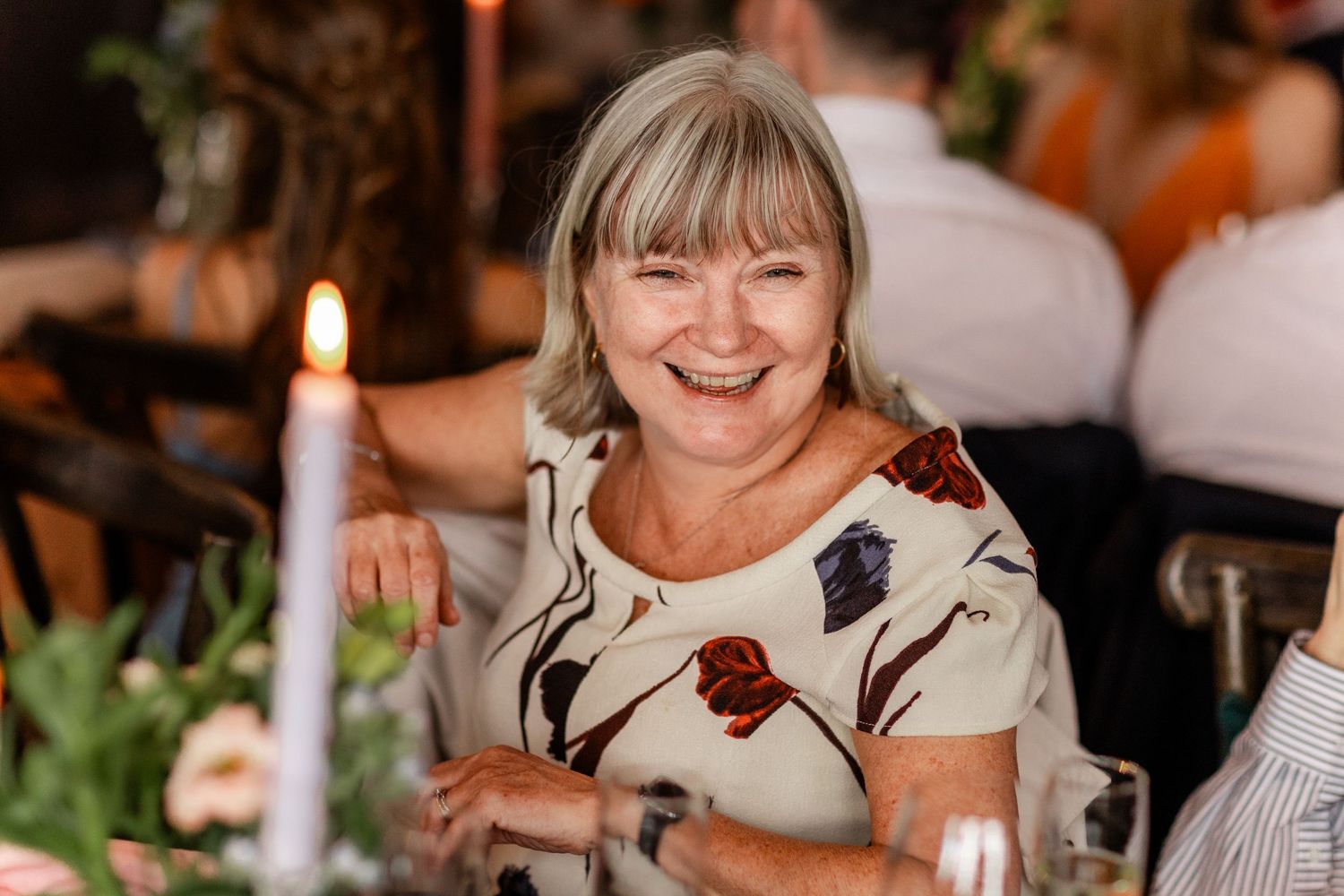 Wedding guests enjoying conversation and laughter at an elegant reception dinner.