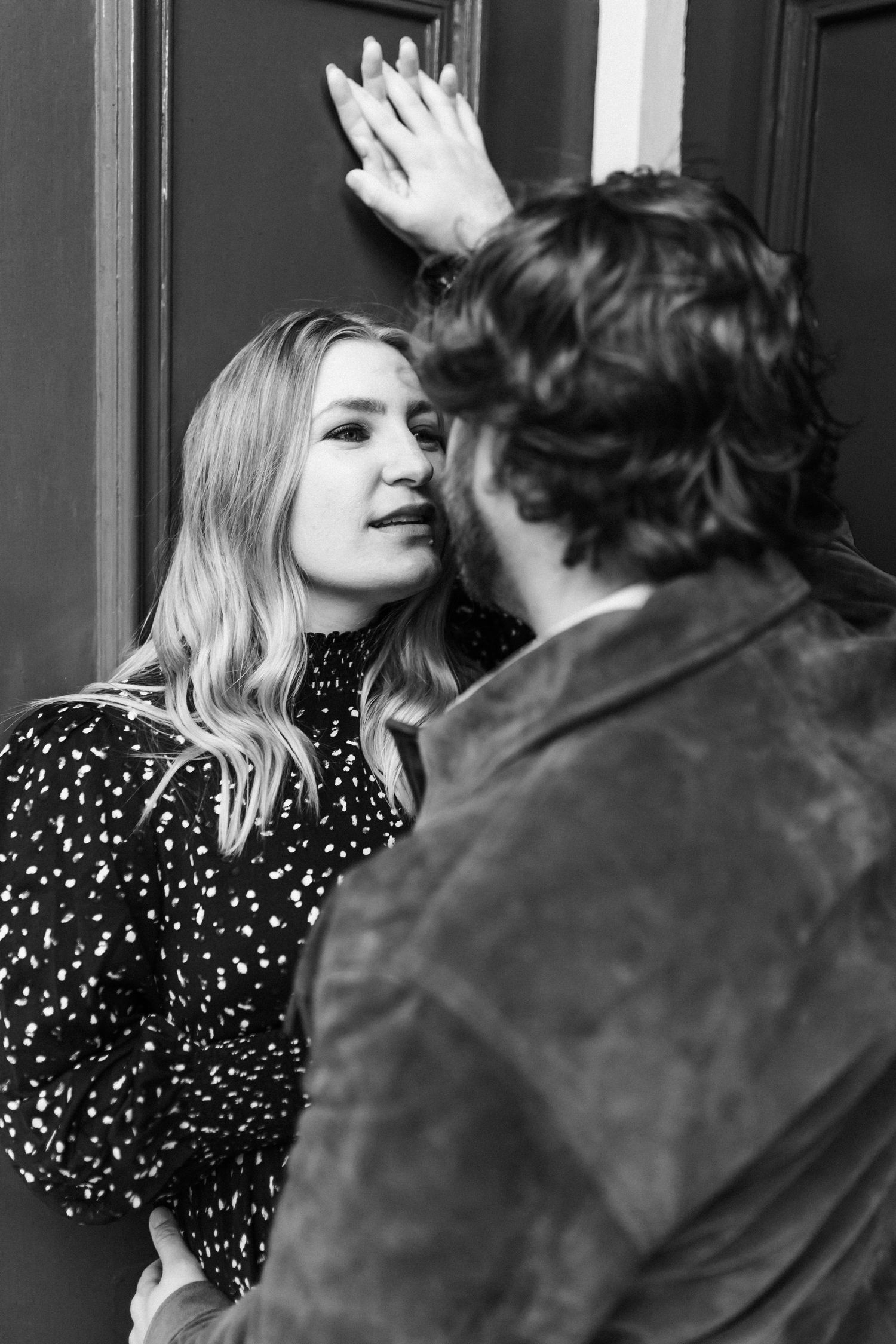 A romantic moment captured between two people wearing polka dots and brown leather.