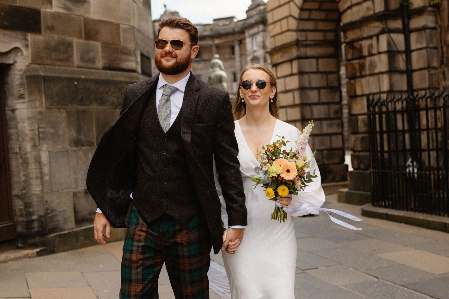 Bride and groom walking around the city  in Edinburgh Scotland