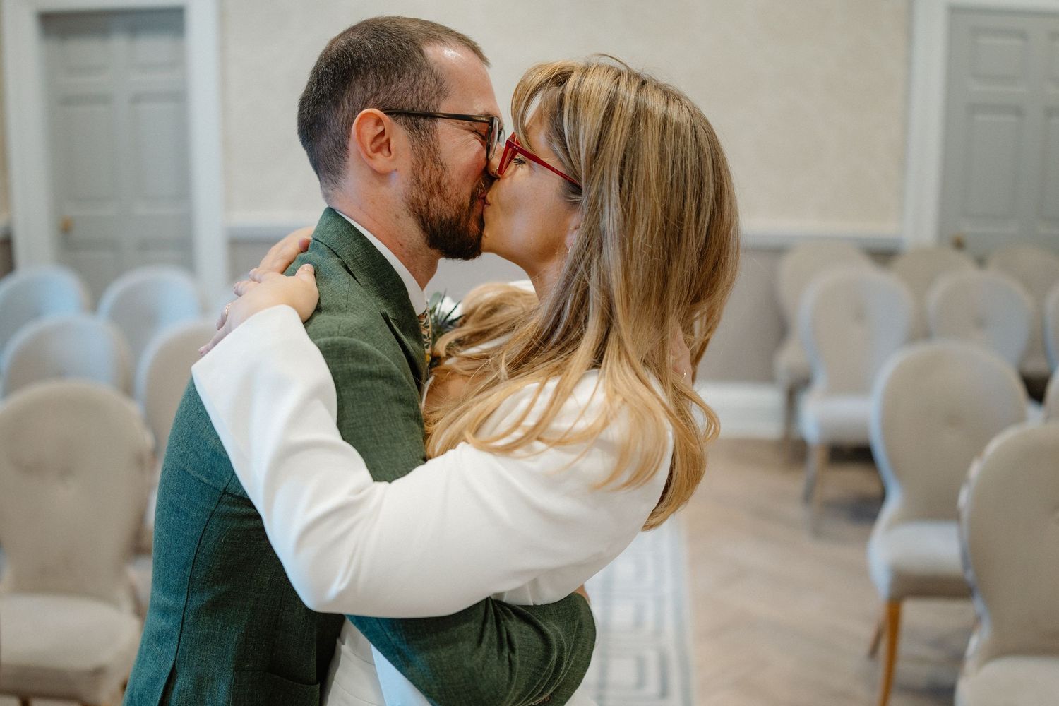 Intimate moments shared between couple in white and green attire in bright indoor setting.