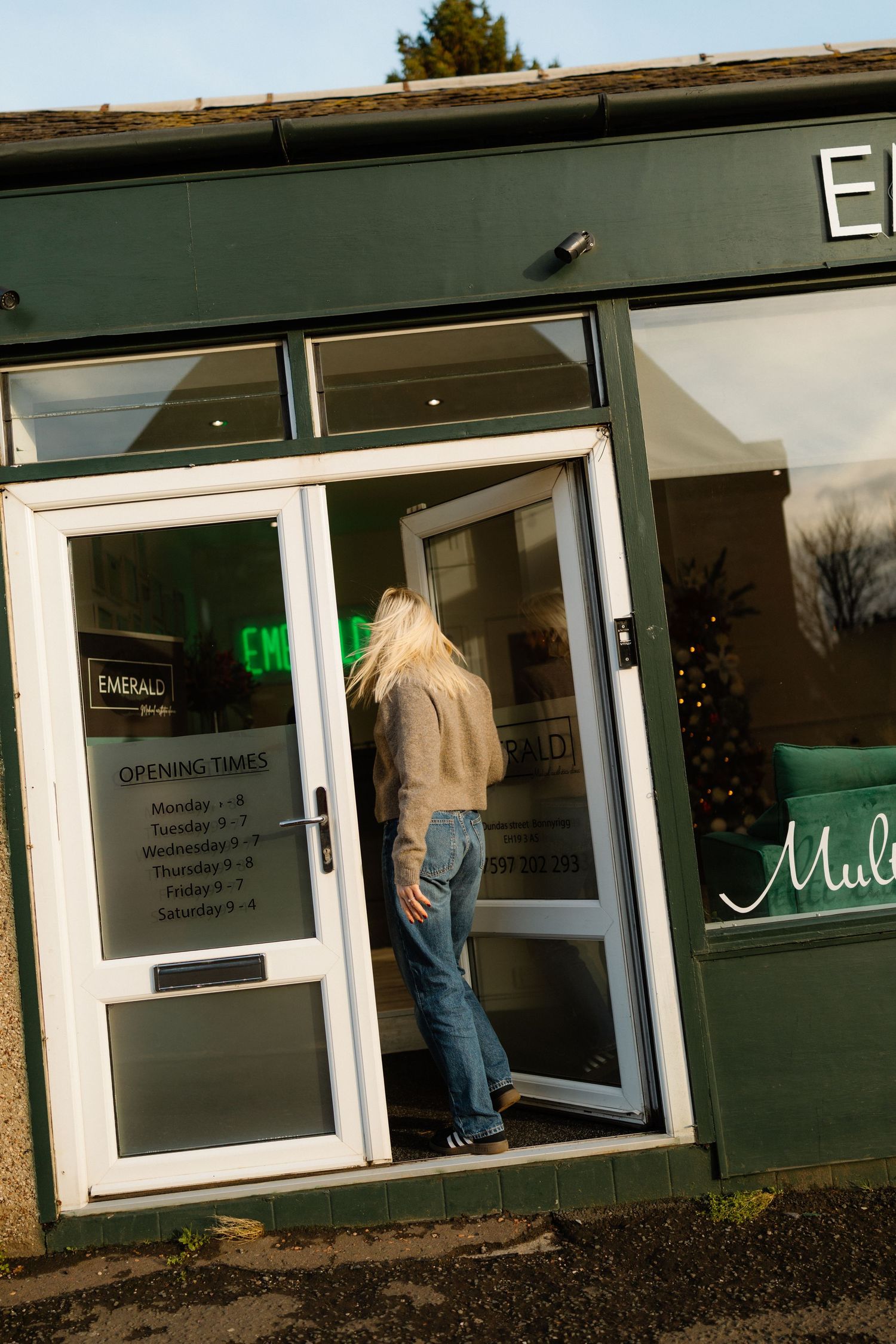 Exterior view of a modern storefront with white-framed glass doors and windows.