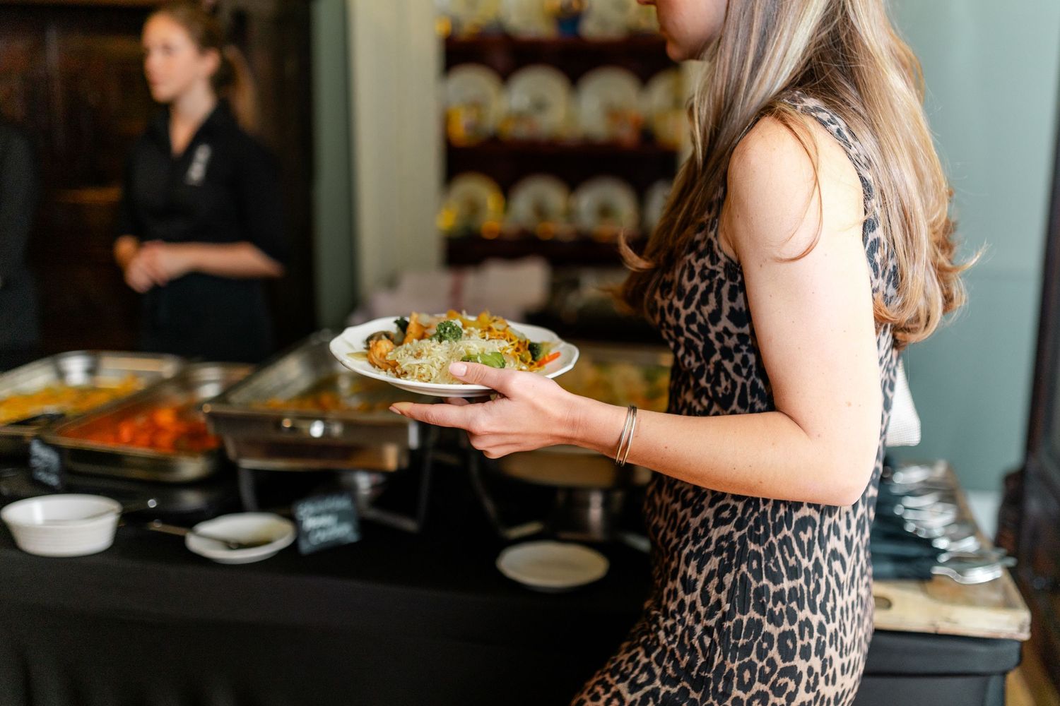 Guests mingle and dine at an elegant indoor social gathering.
