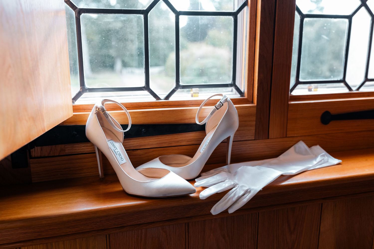 White sheer curtains gently blowing in the breeze through open windows with decorative glass panes.