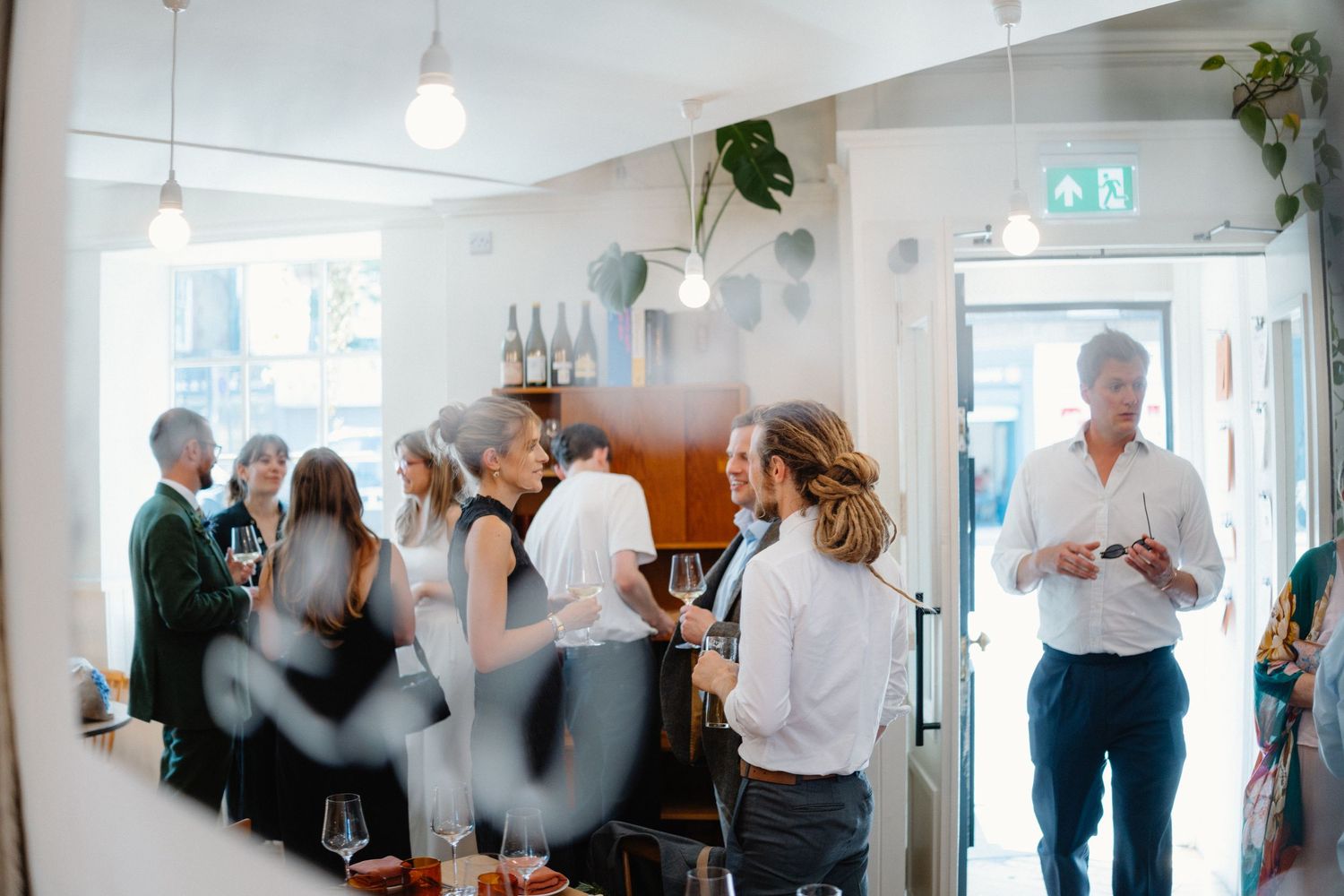 People mingling in a bright modern space with pendant lighting.