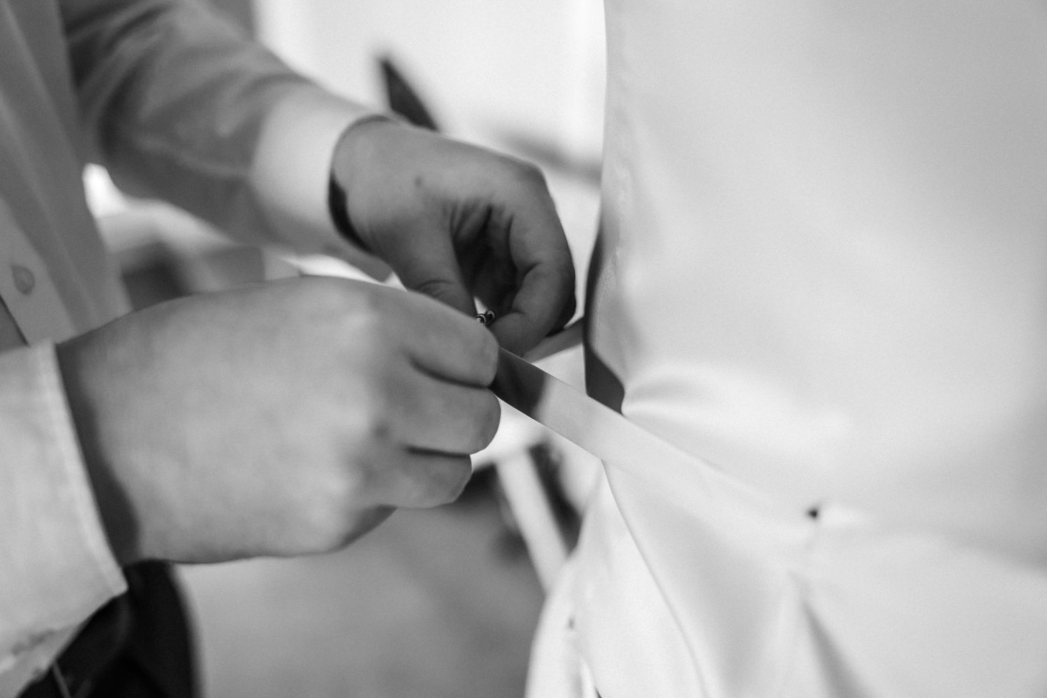 Close-up shots of hands adjusting formal wear details and accessories.