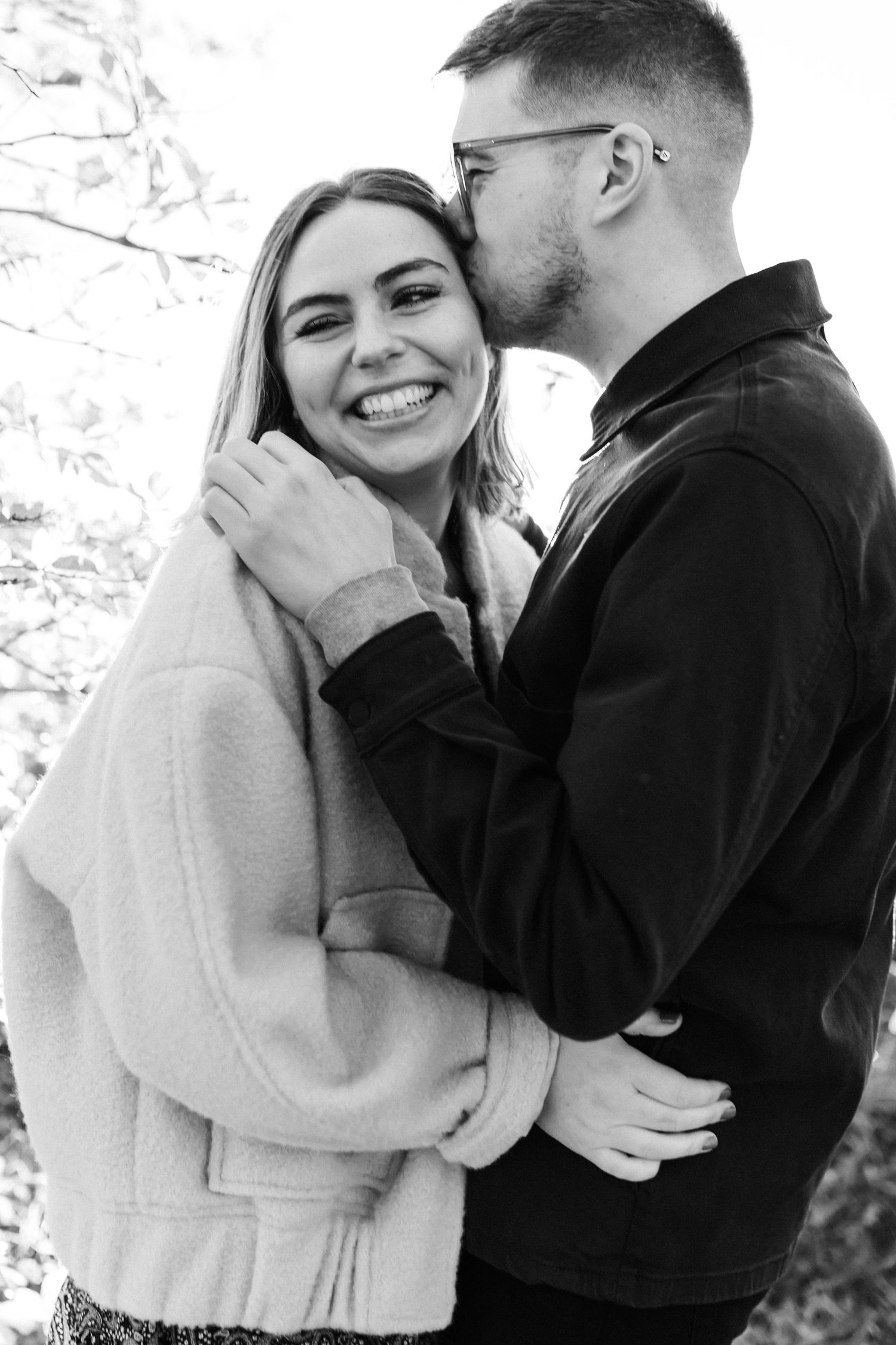 Intimate winter engagement photos showing a couple in warm clothing sharing tender moments.