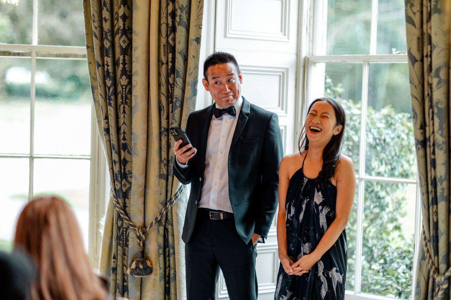 Guests laughing and socializing during an elegant indoor wedding reception.