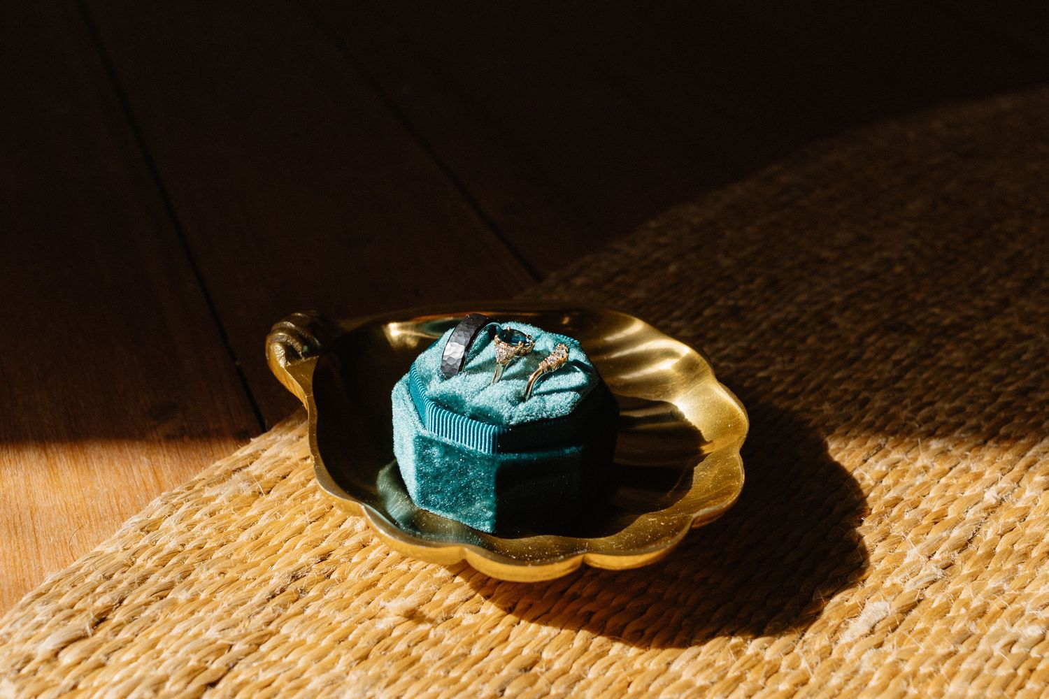 Wedding shoes arranged artistically on a textured carpet with dramatic lighting.