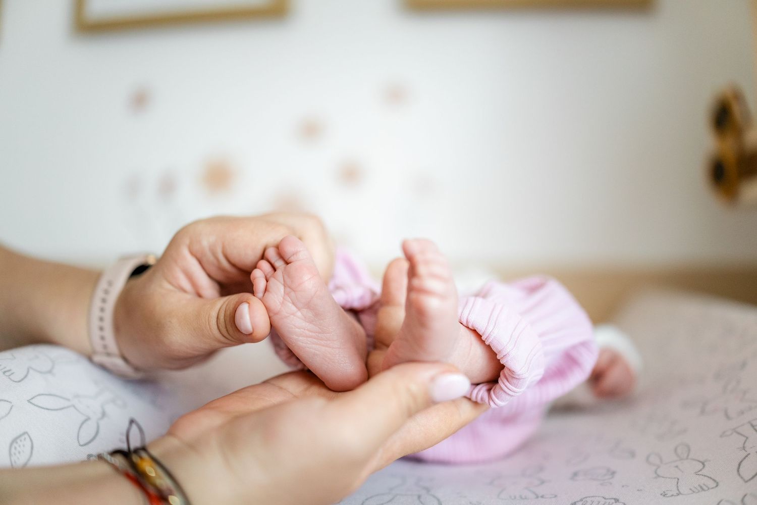 Close up of tiny baby hands resting on a textured surface.