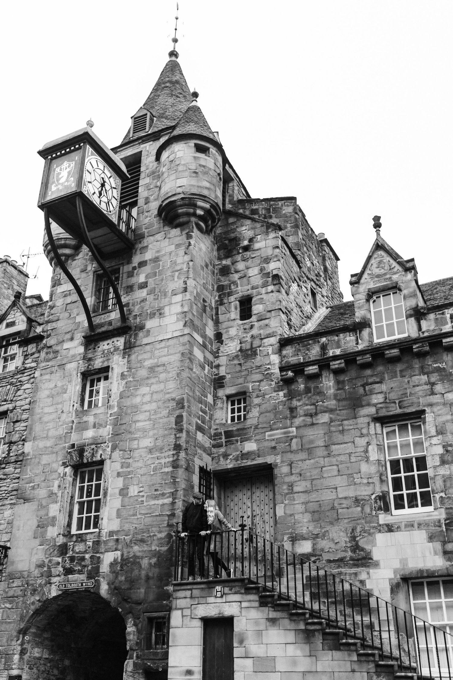 Historic stone buildings with gothic architecture and clock tower in Edinburgh's old town.