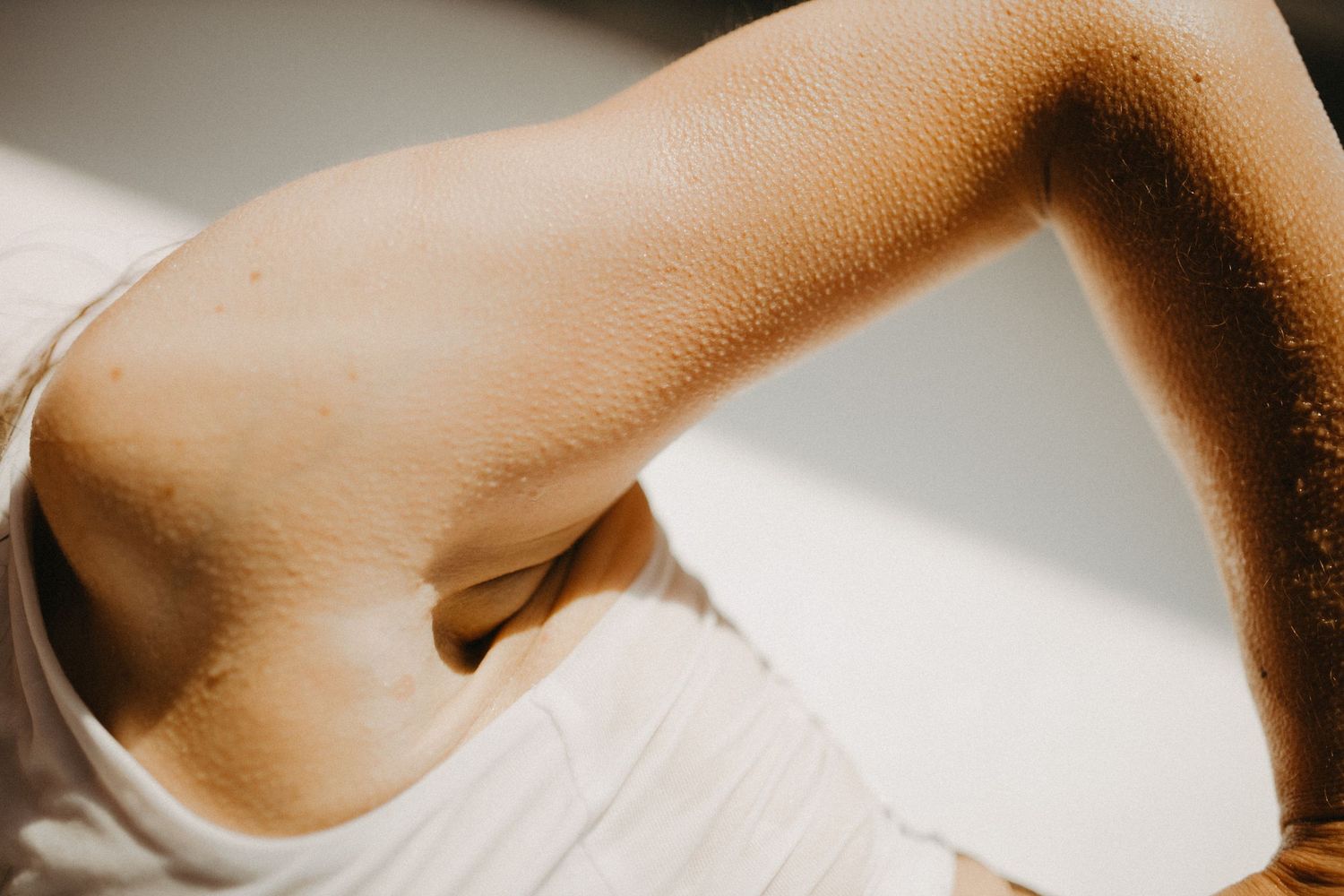Abstract close-up photograph showing skin tones in warm lighting.