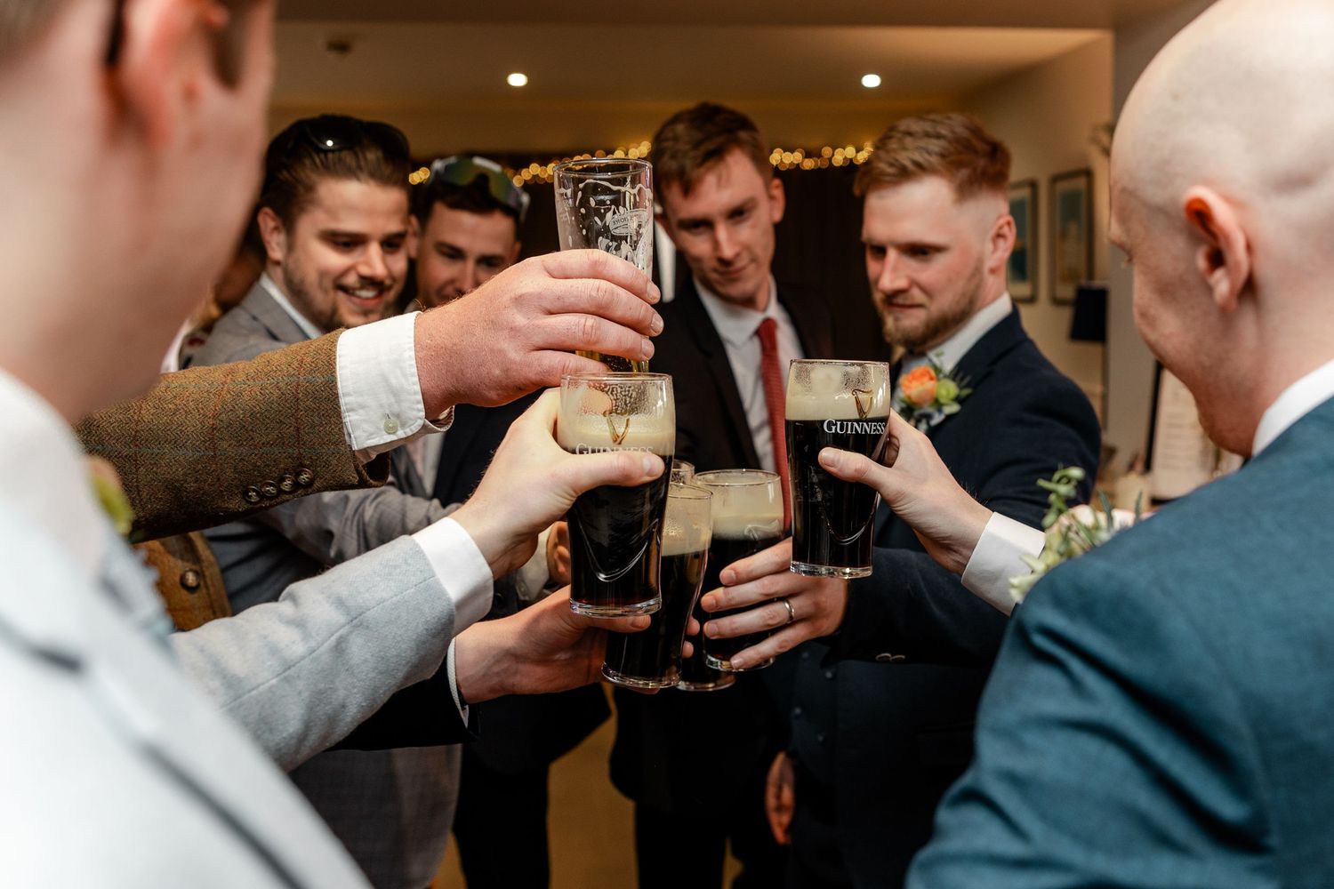Wedding party toasting with drinks at an indoor reception.