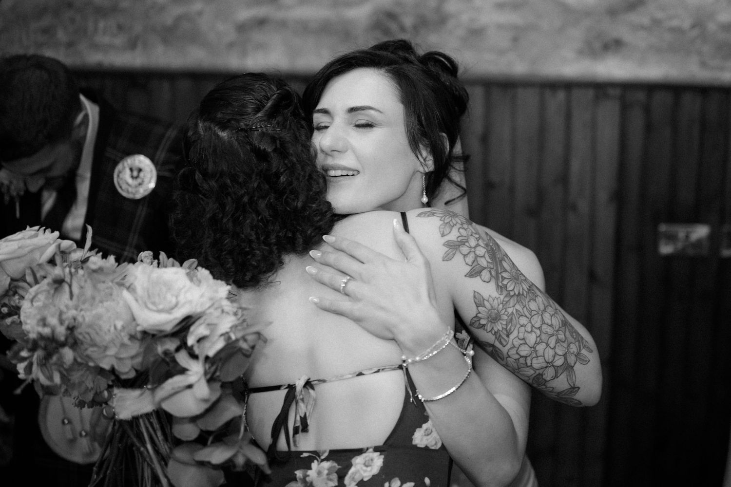 Bride hugging cousin at Rosebery Steading, Temple, Gorebridge, Scotland.