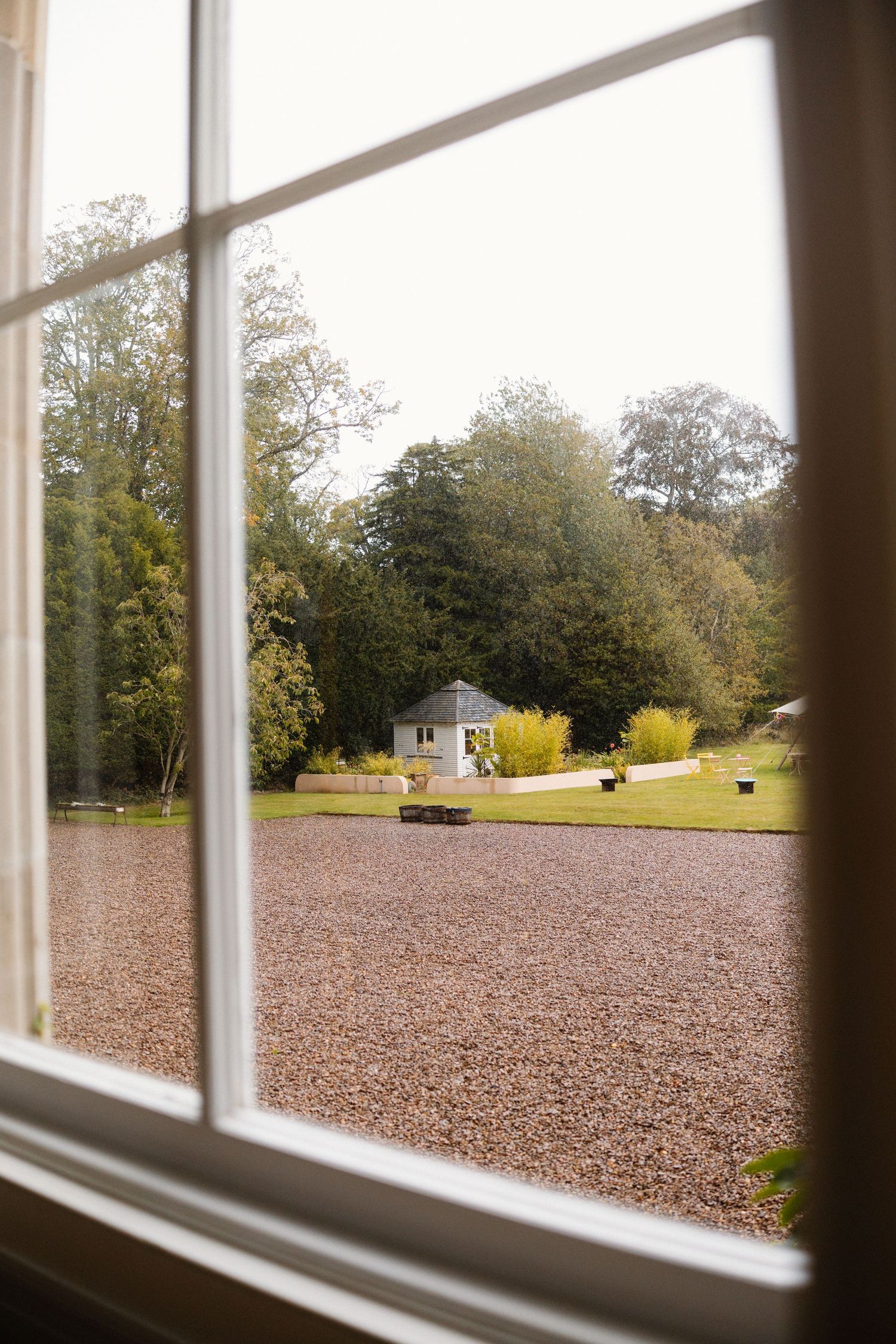 Scenic view of a grassy landscape through large white-framed windows.