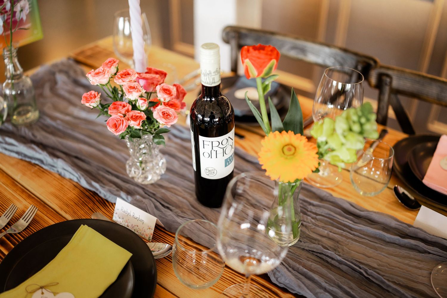 Elegant table settings with colorful floral centerpieces and wine glasses at a wedding reception.