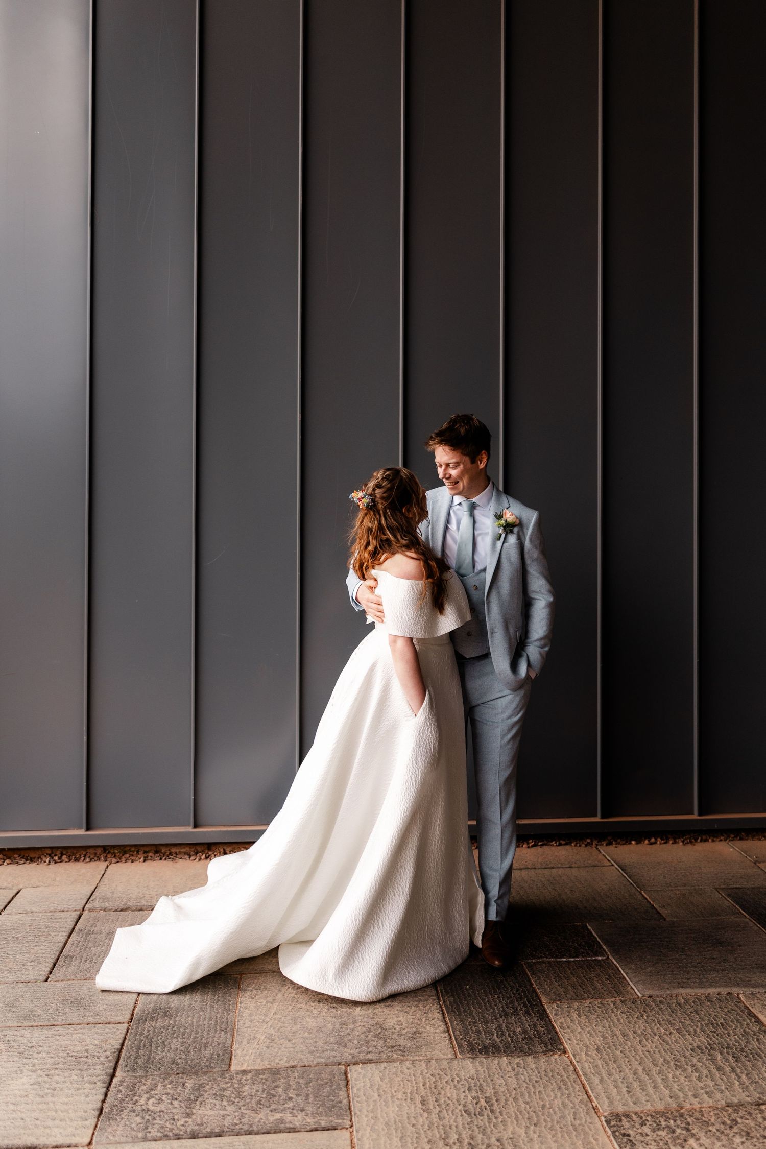 Modern wedding portrait against dark vertical panels.