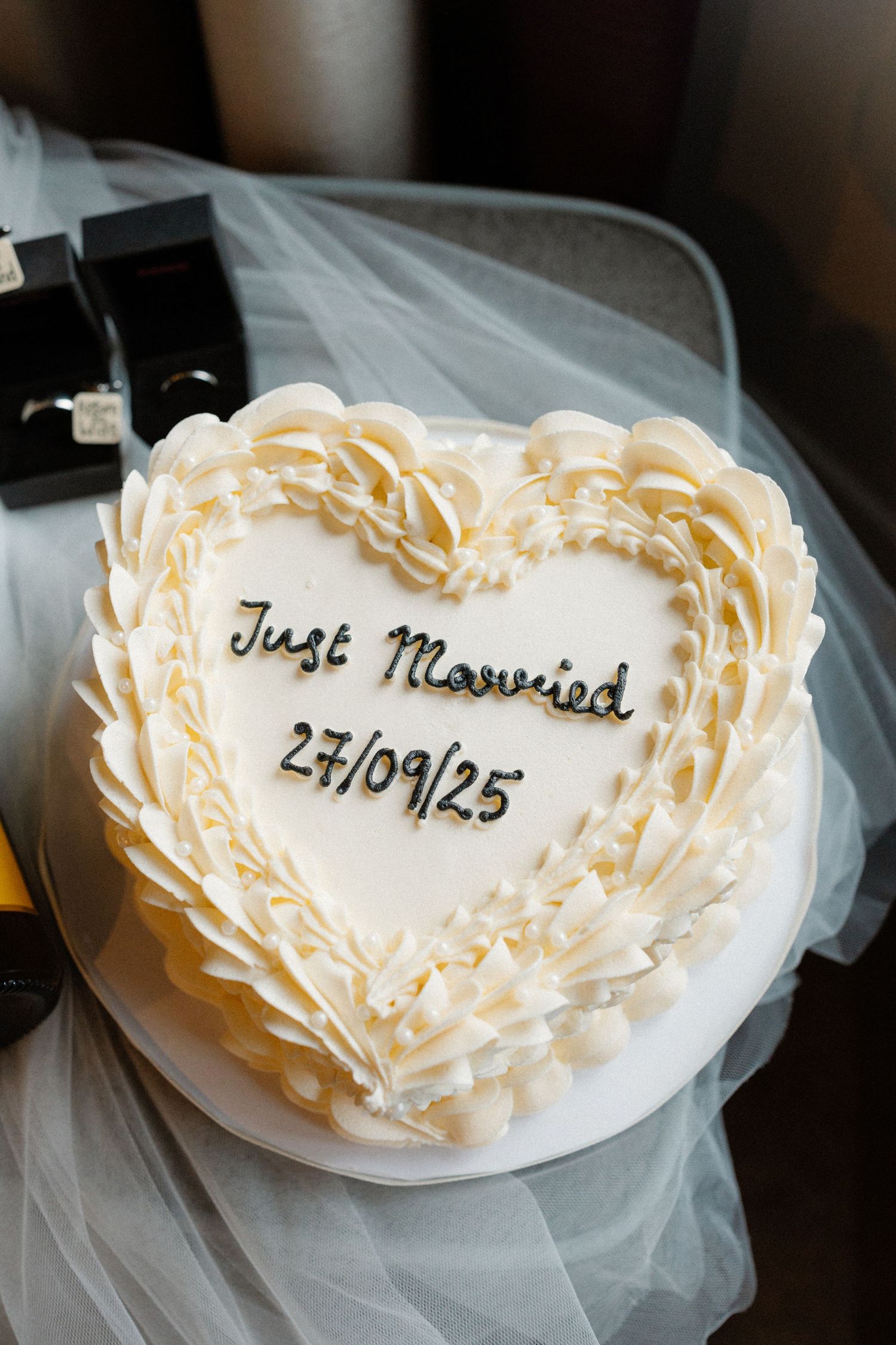 Heart-shaped wedding cake decoration with 'Just Married' text and date.