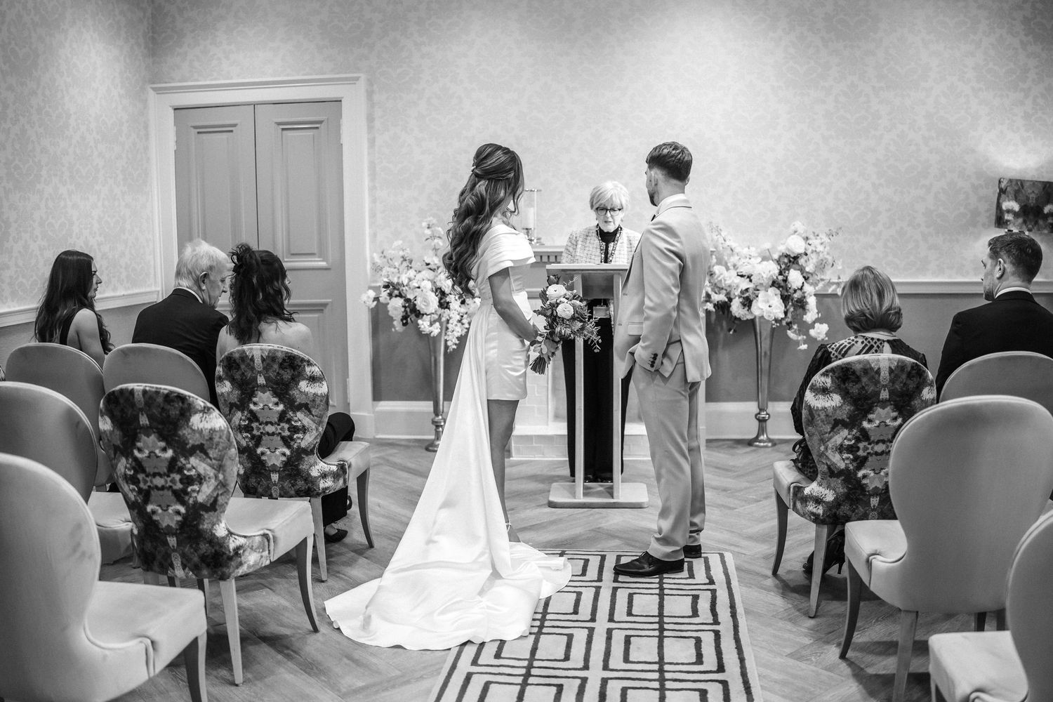 A series of black and white wedding photographs showing ceremony and reception moments in a traditional venue setting.