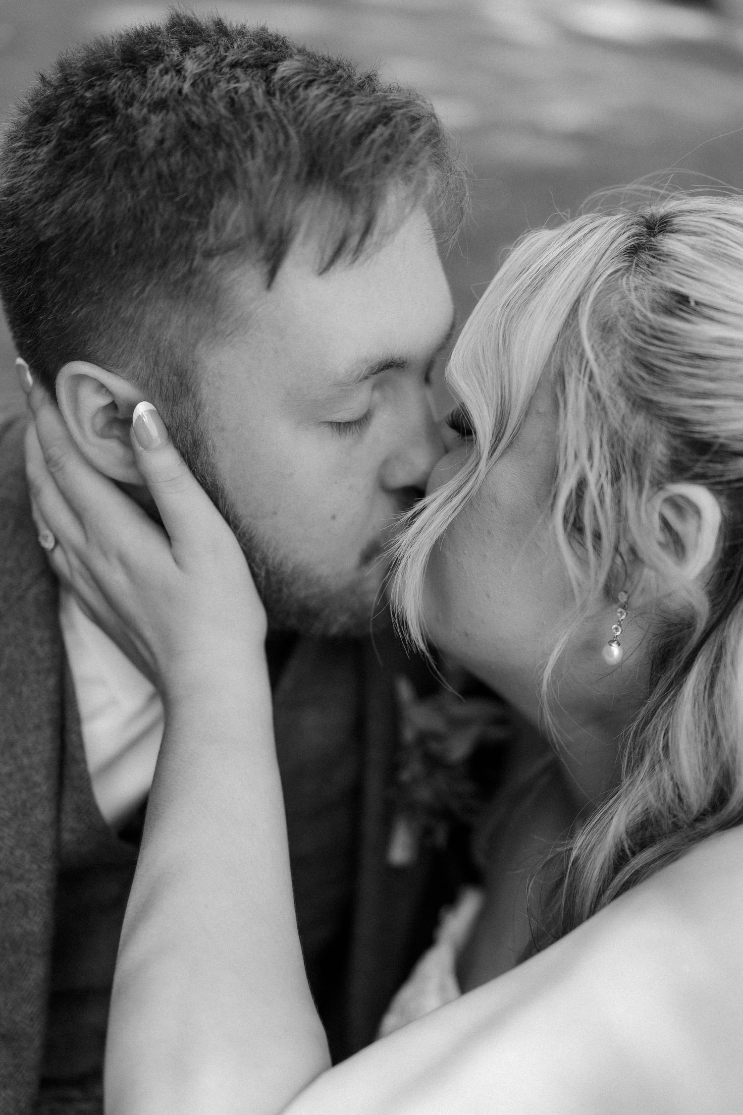 Black and white photo of bride and groom sharing a romantic kiss on their wedding day.