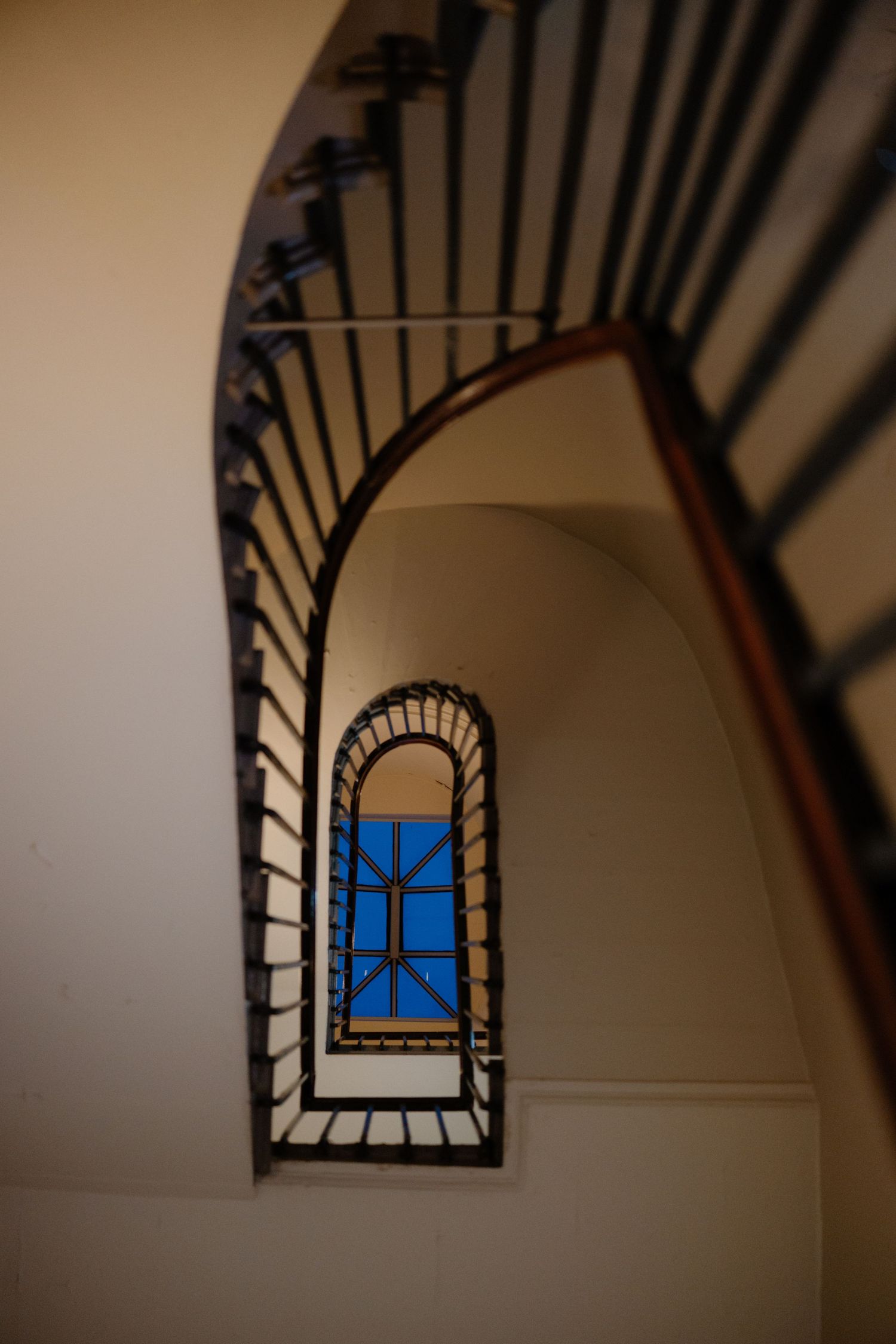 Architectural sequence showing a stairwell window frame from different angles with blue sky visible through arched opening.