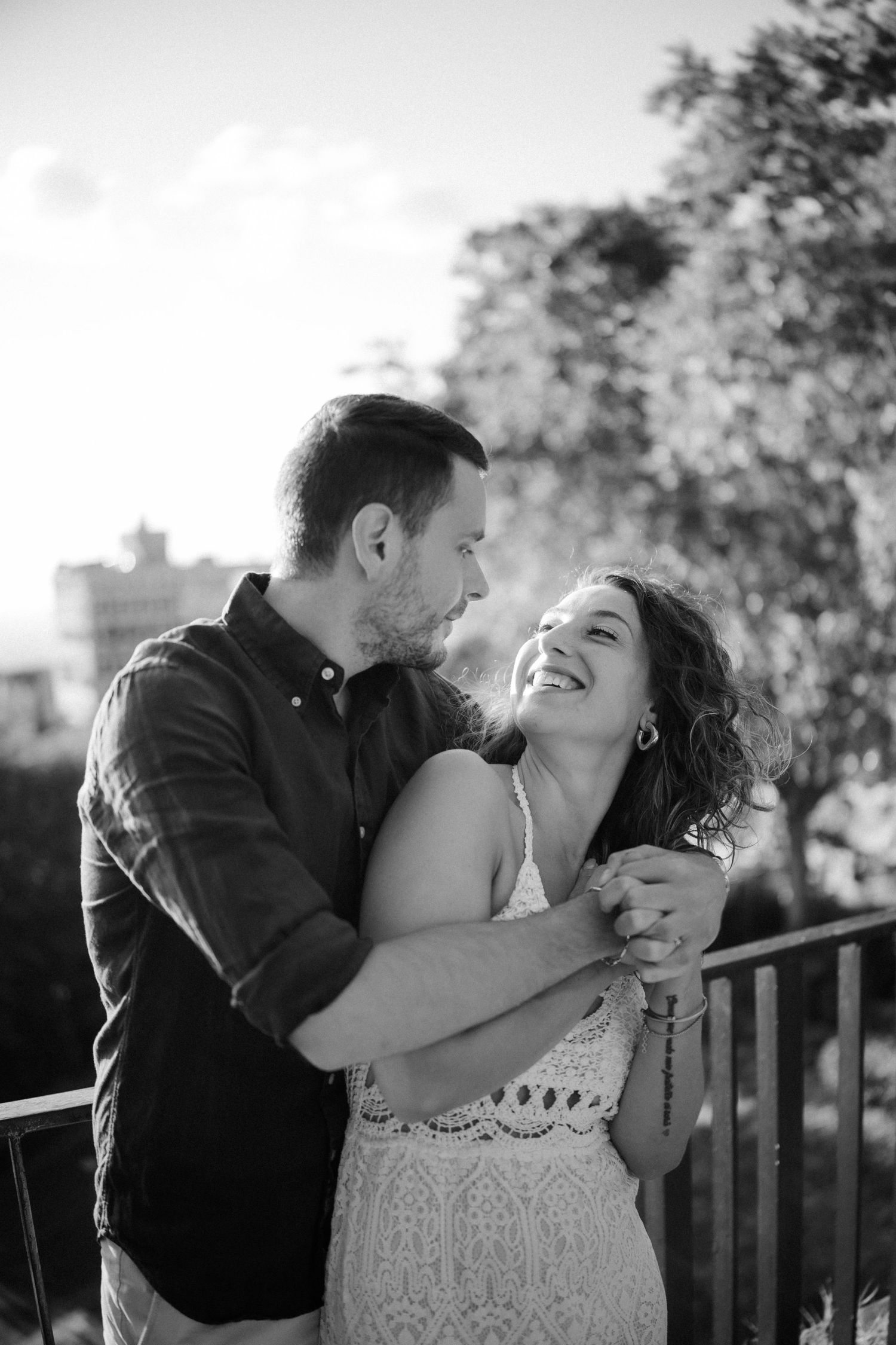 A couple shares joyful romantic moments together in black and white photography.