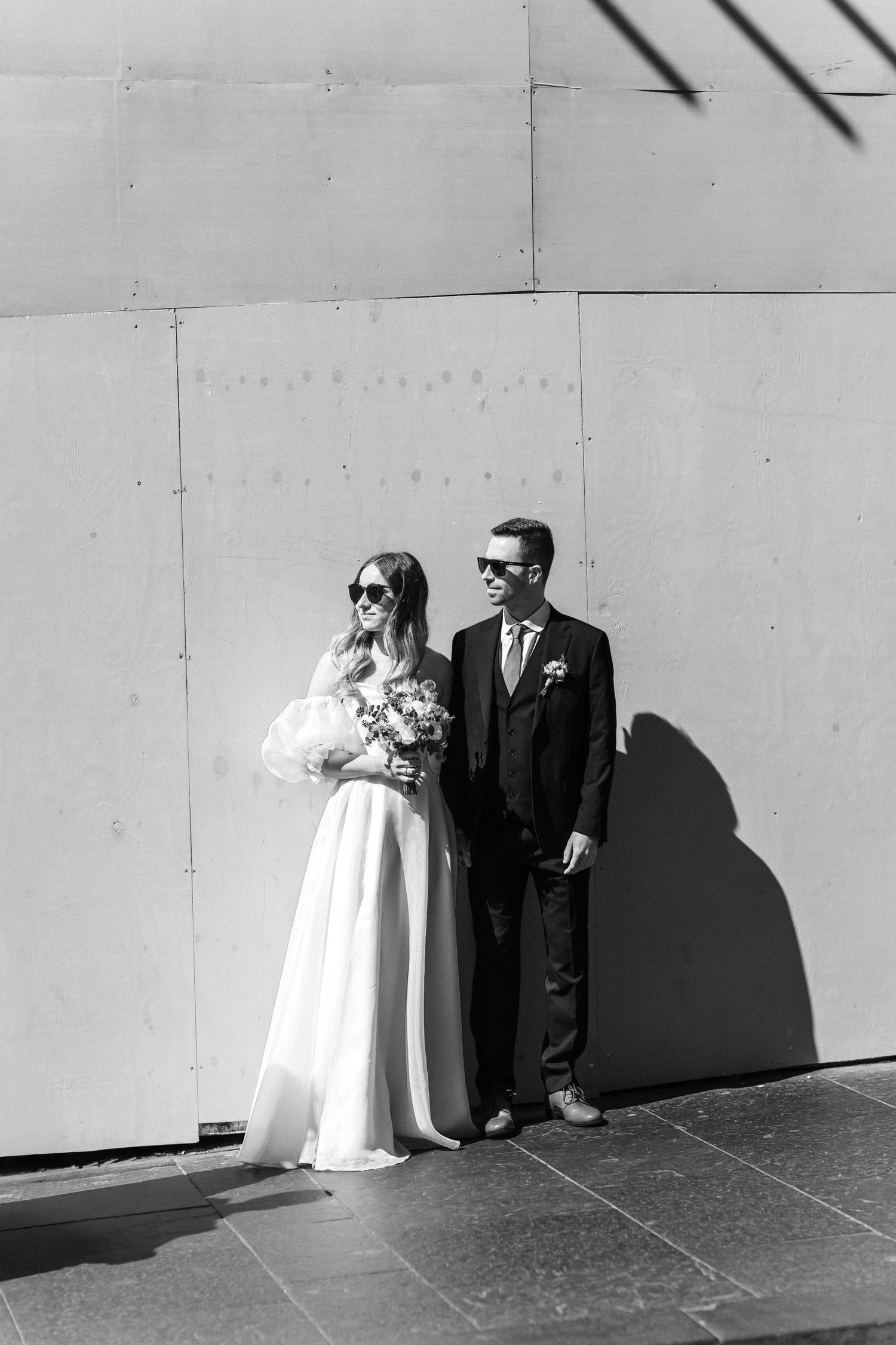 A black and white series of artistic wedding portraits against a minimalist white wall.