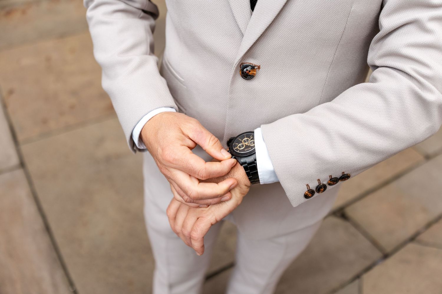 A close-up detail shot of a light gray suit jacket sleeve and cuff.