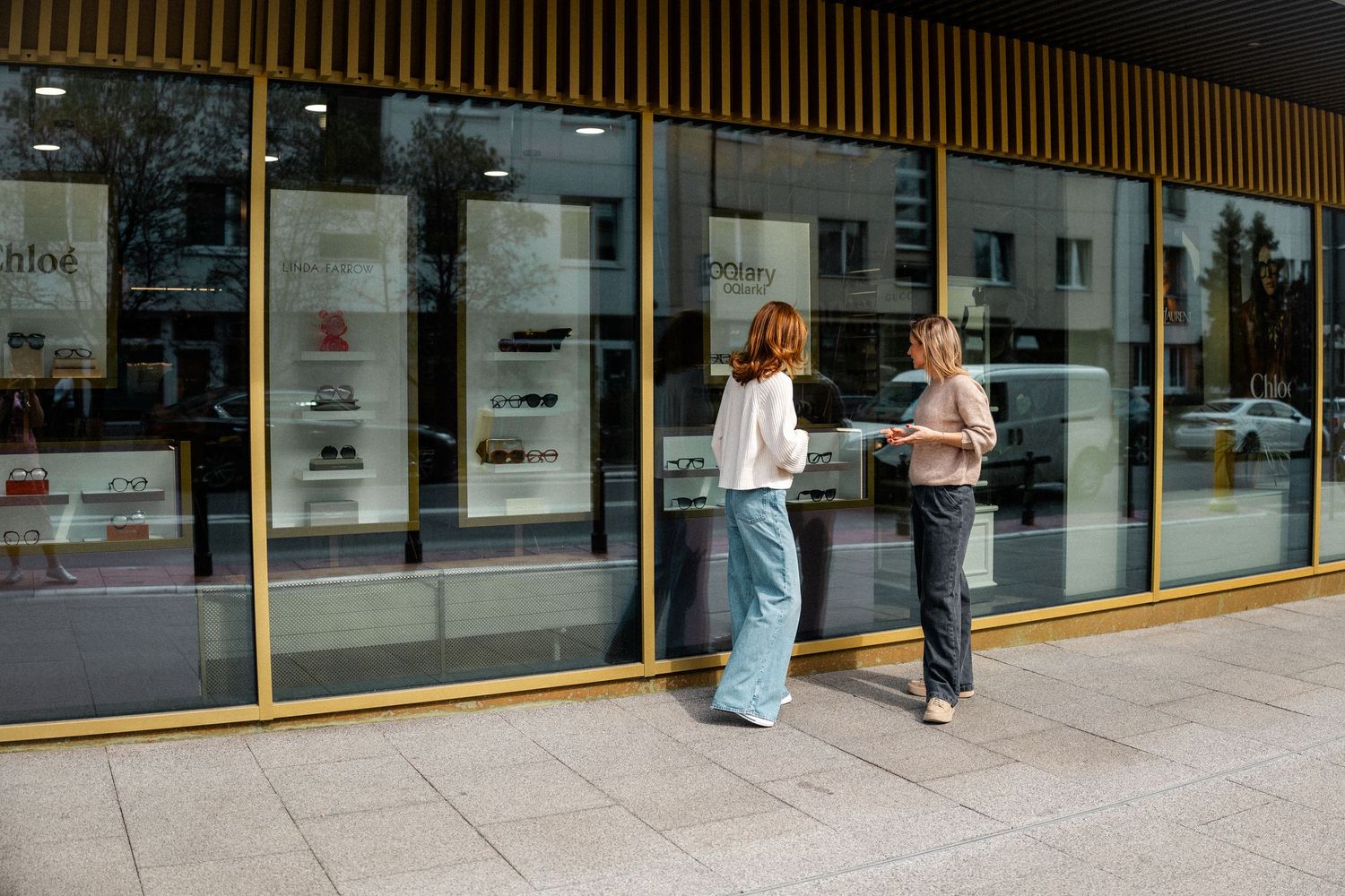Wide panoramic view of a storefront with glass windows and gold trim.