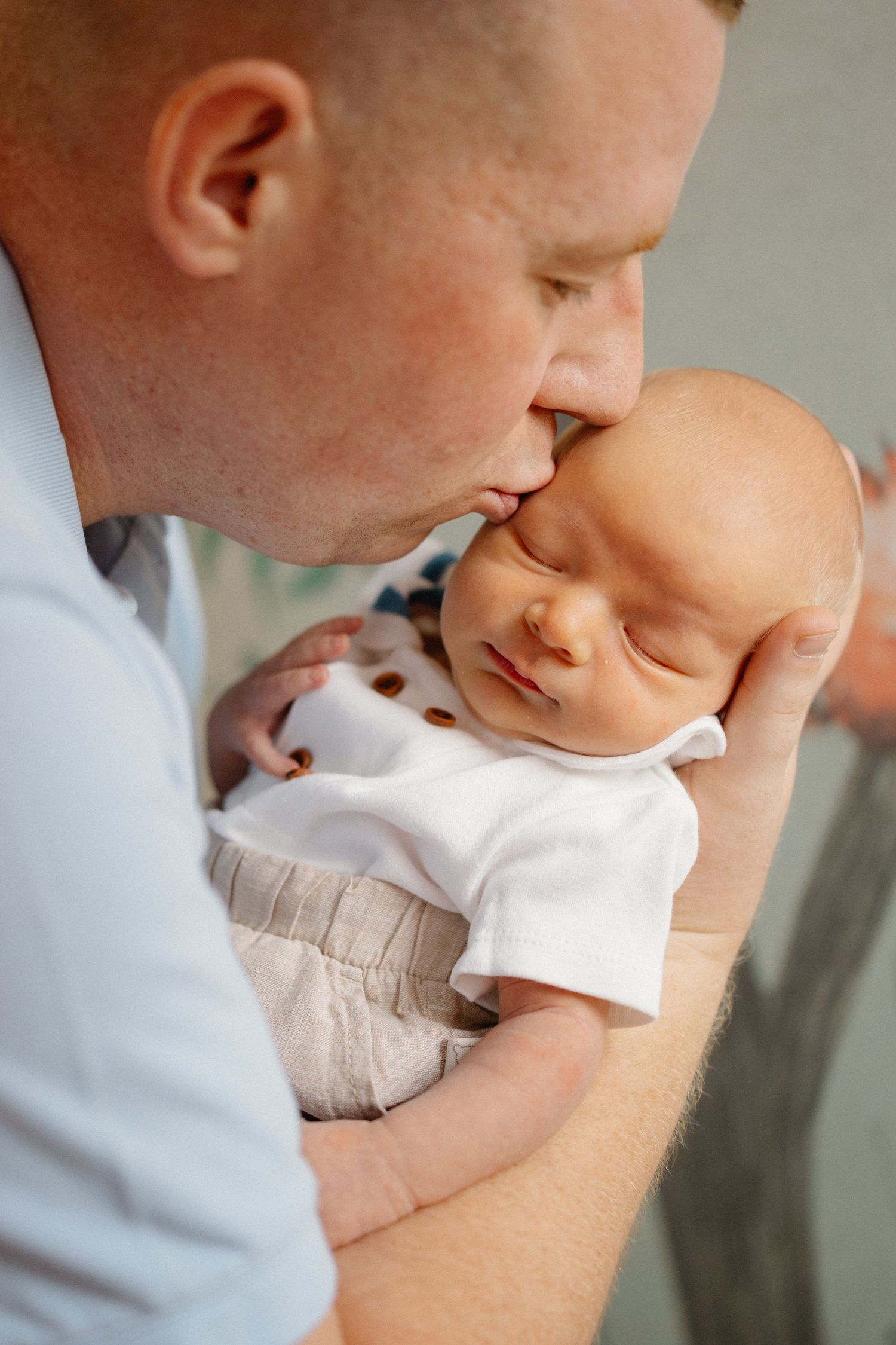 Close-up shots of tender moments with a baby in white clothing.