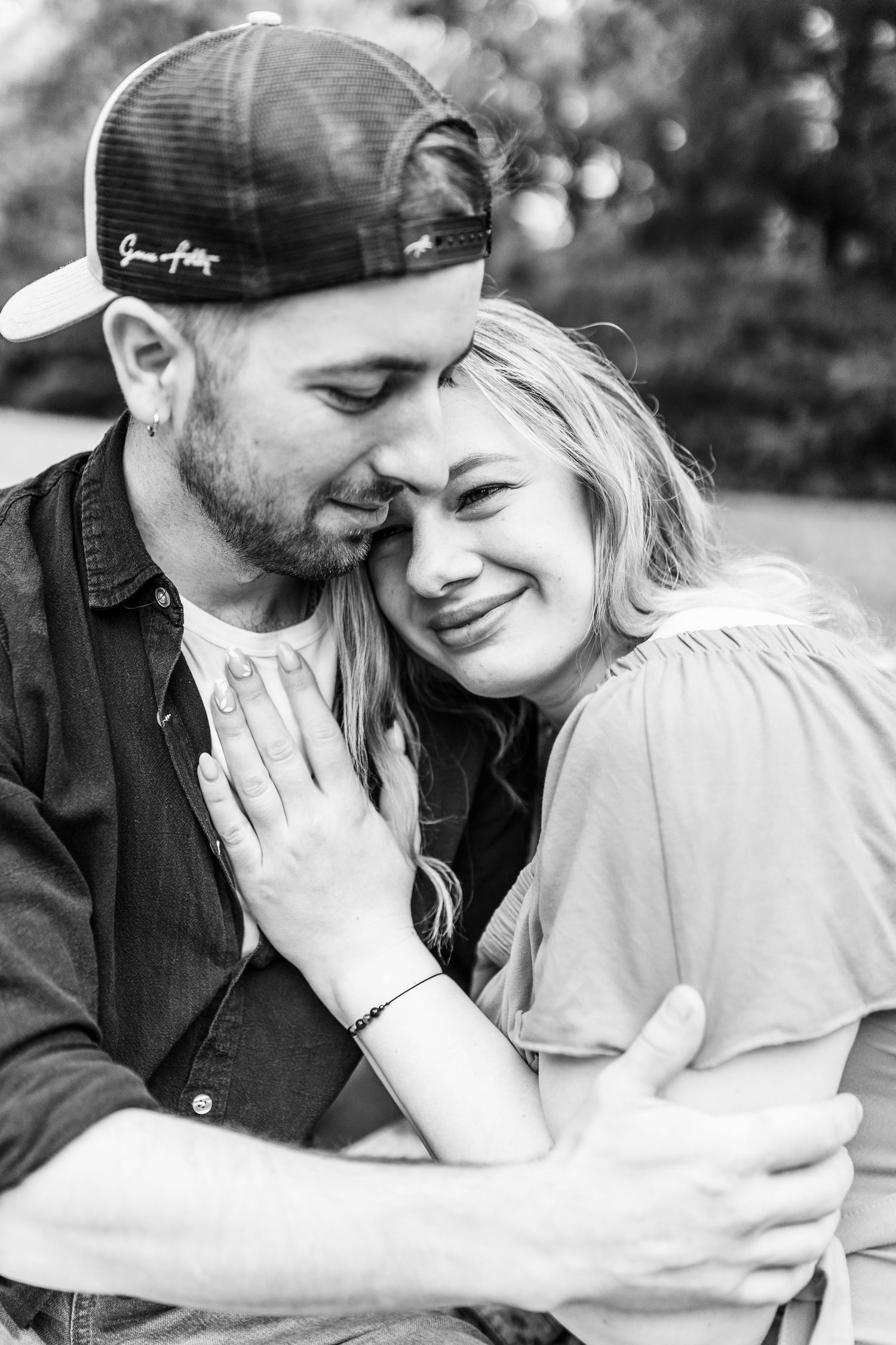 Black and white intimate portrait of couple sharing tender moment outdoors.
