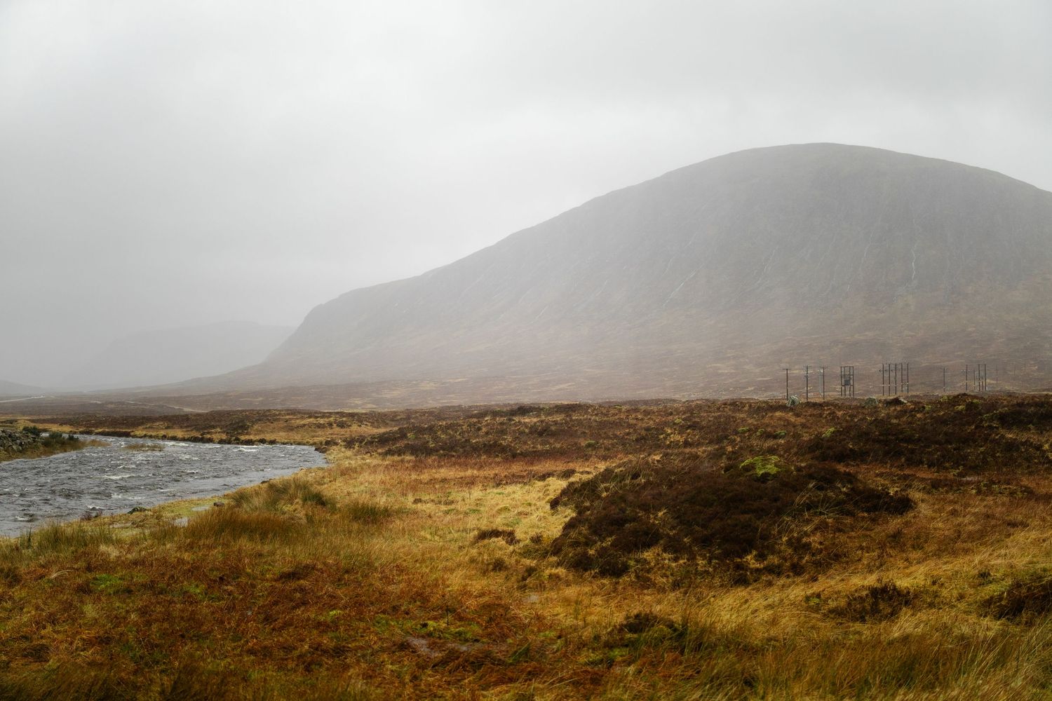 Misty mountain panorama showing golden moorland and distant hills in the Scottish Highlands.