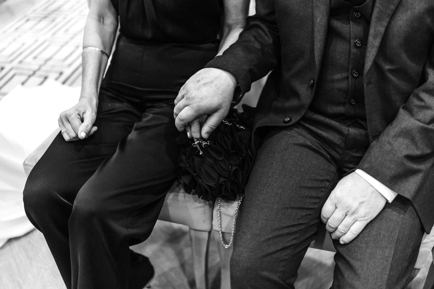 Black and white photo of wedding guests seated in formal attire.