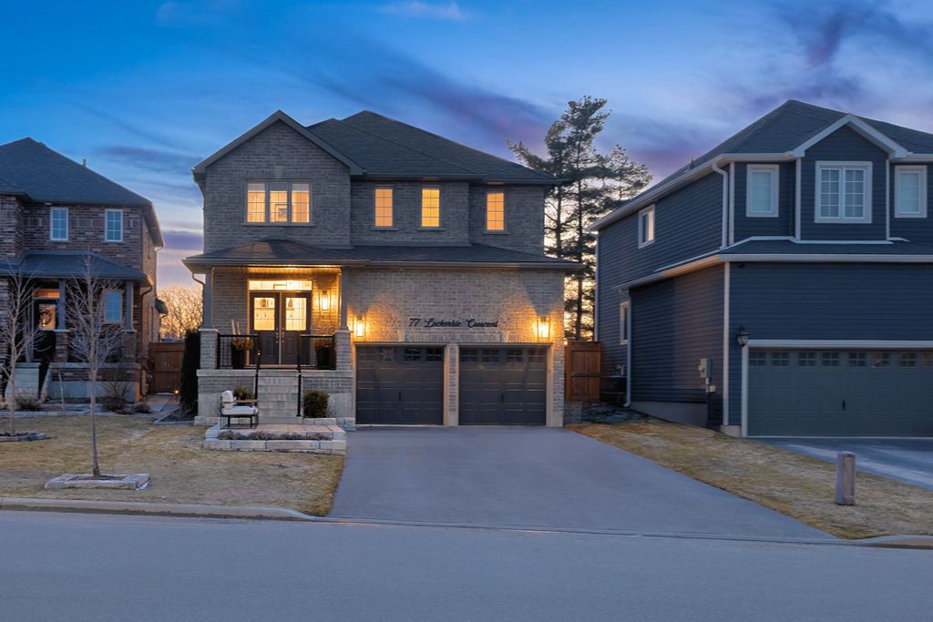 Elegant two-story brick and stone home with double garage photographed at twilight on a quiet street.