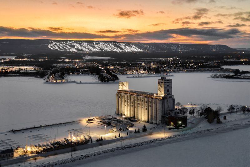 Aerial winter night view of the terminals in Collingwood Ontario surrounded by snow with a golden sunset sky.