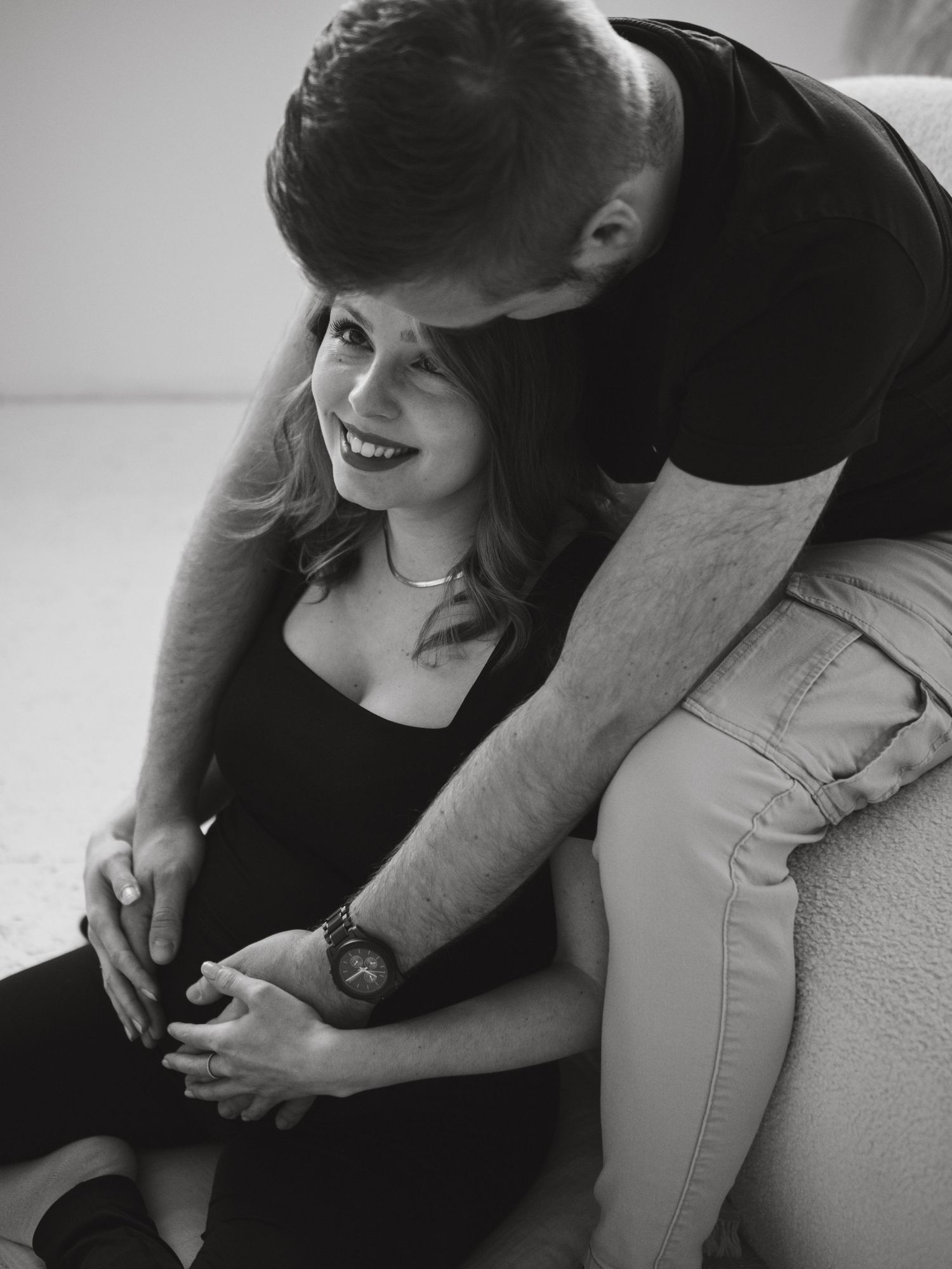 A tender black and white photograph capturing an intimate moment between a couple sharing a joyful laugh together.